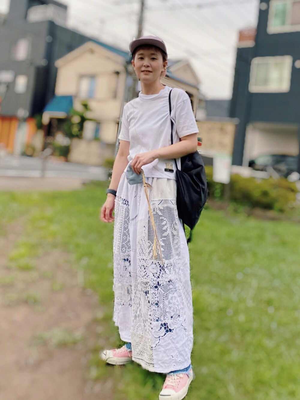 ホワイト系のスカート、ピンク系のスニーカー、ホワイト系のTシャツ/カットソーを着用したレディースの夏コーディネートの1枚目の写真