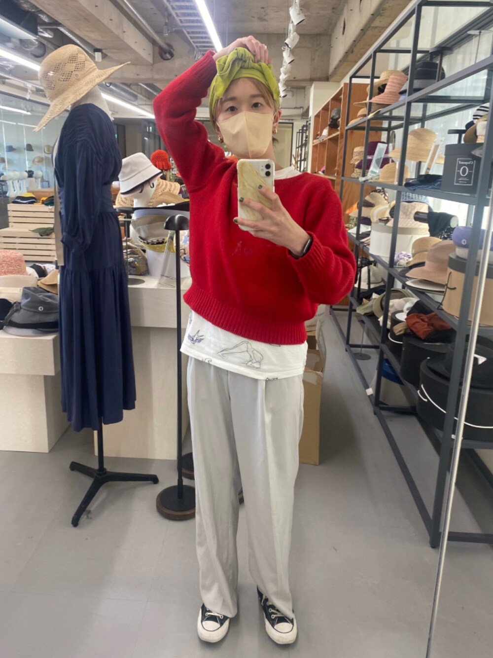 レッド系のニット/セーター、ブラック系のスニーカー、ホワイト系のTシャツ/カットソーを着用したレディースの冬コーディネートの1枚目の写真