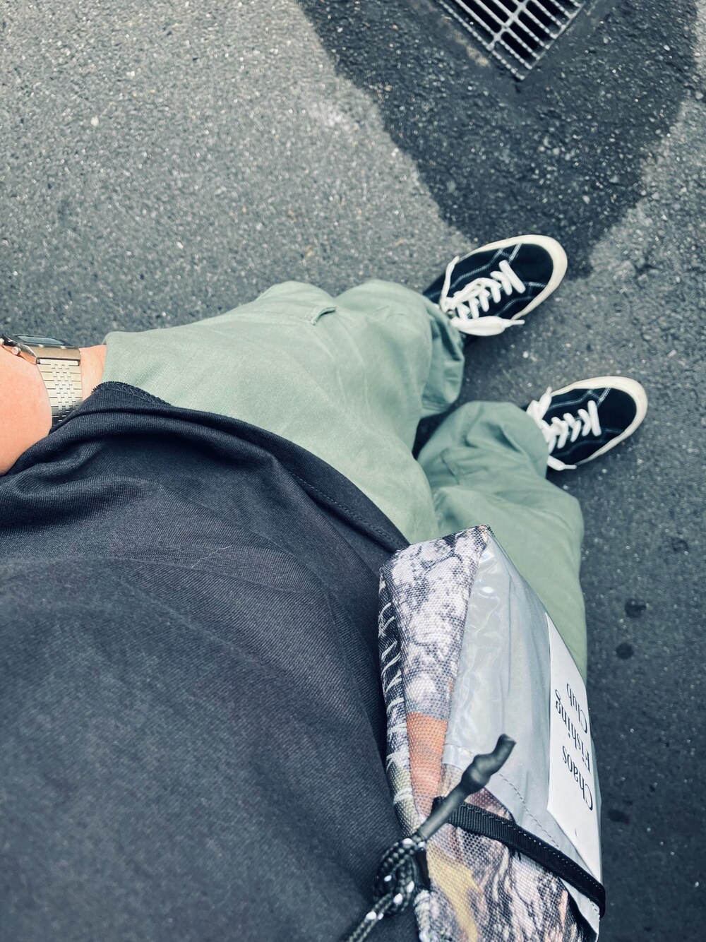 グリーン系のショルダーバッグ、シルバー系のデジタル腕時計を着用したメンズの夏コーディネートの1枚目の写真