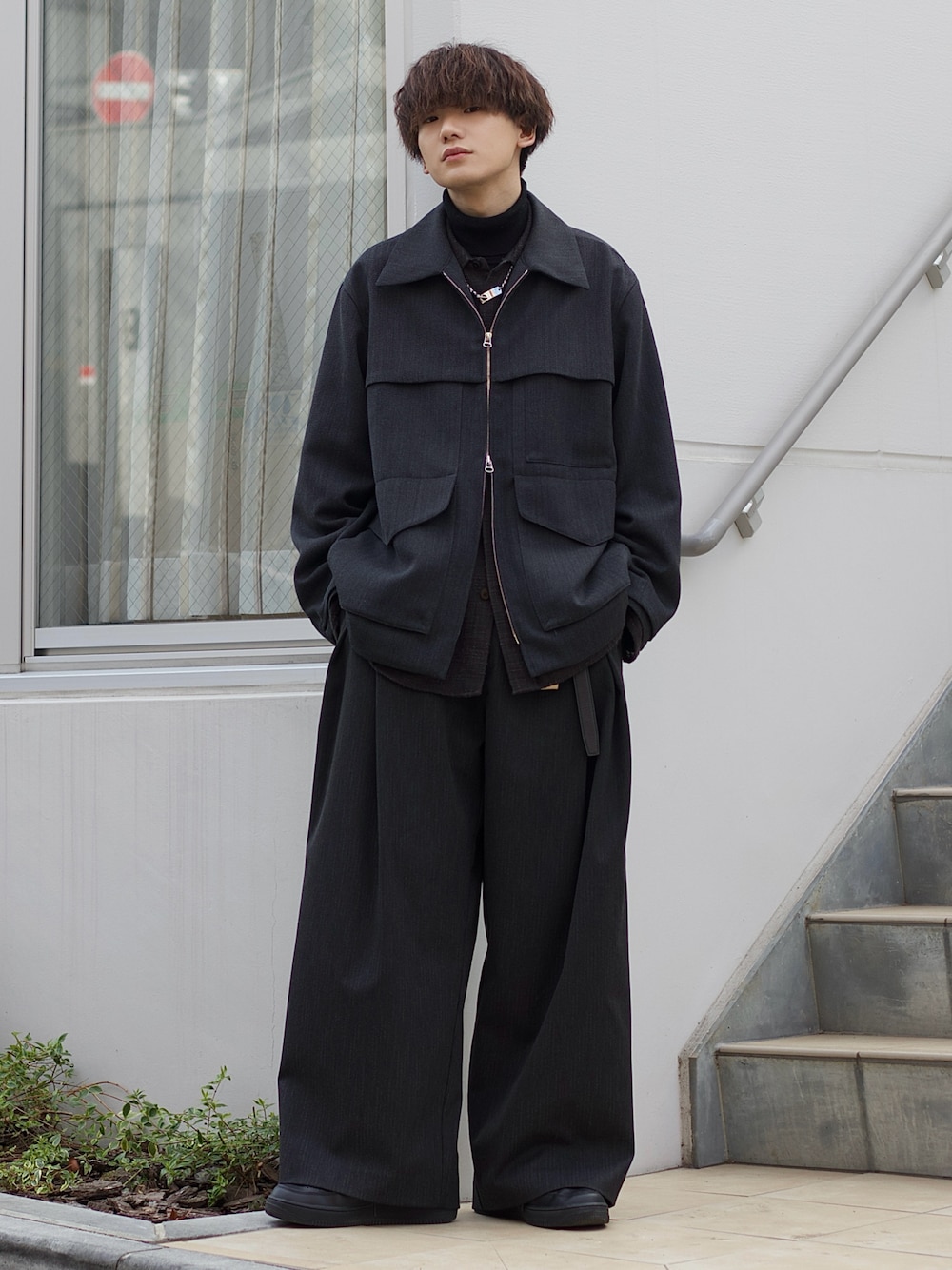 グレー系のブルゾン、グレー系のシャツ/ブラウス、ブラック系のニット/セーターを着用したメンズの冬コーディネートの1枚目の写真