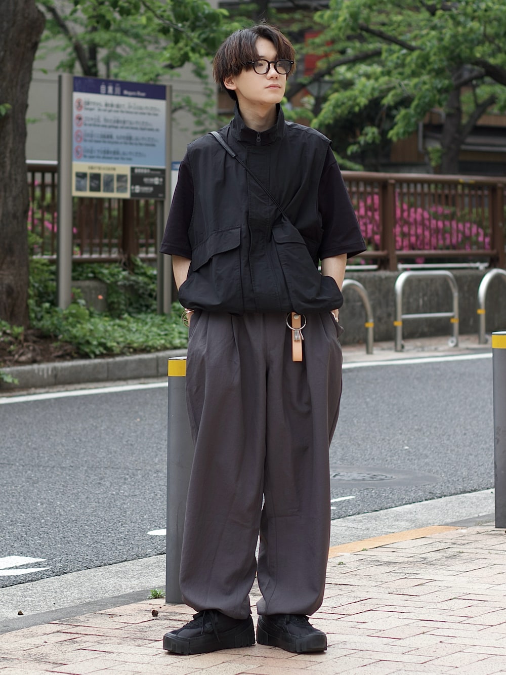 ブラック系のベスト、ブラック系のTシャツ/カットソー、グレー系のカーゴパンツを着用したメンズの春コーディネートの1枚目の写真