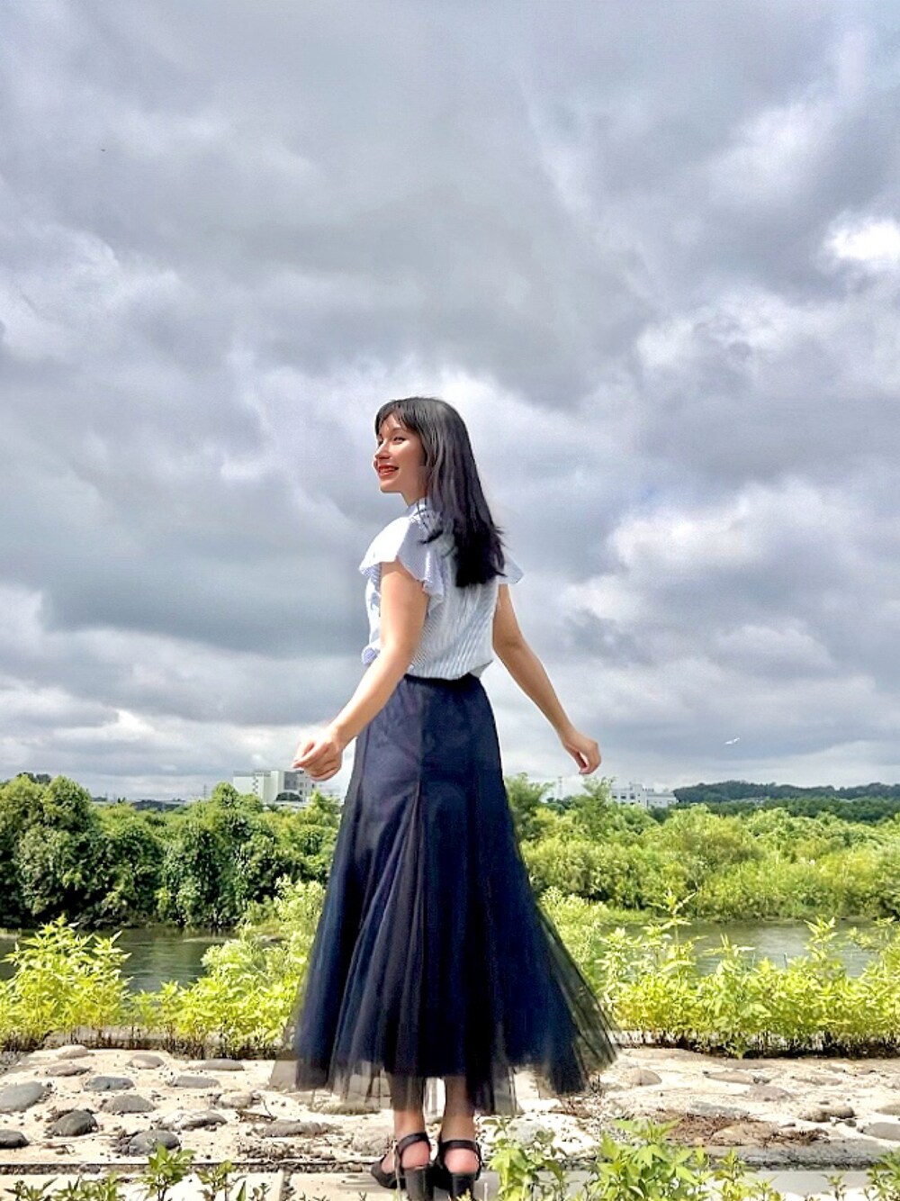 ブルー系のスカート、ブラック系のサンダル、ブルー系のシャツ/ブラウスを着用したレディースの夏コーディネートの1枚目の写真