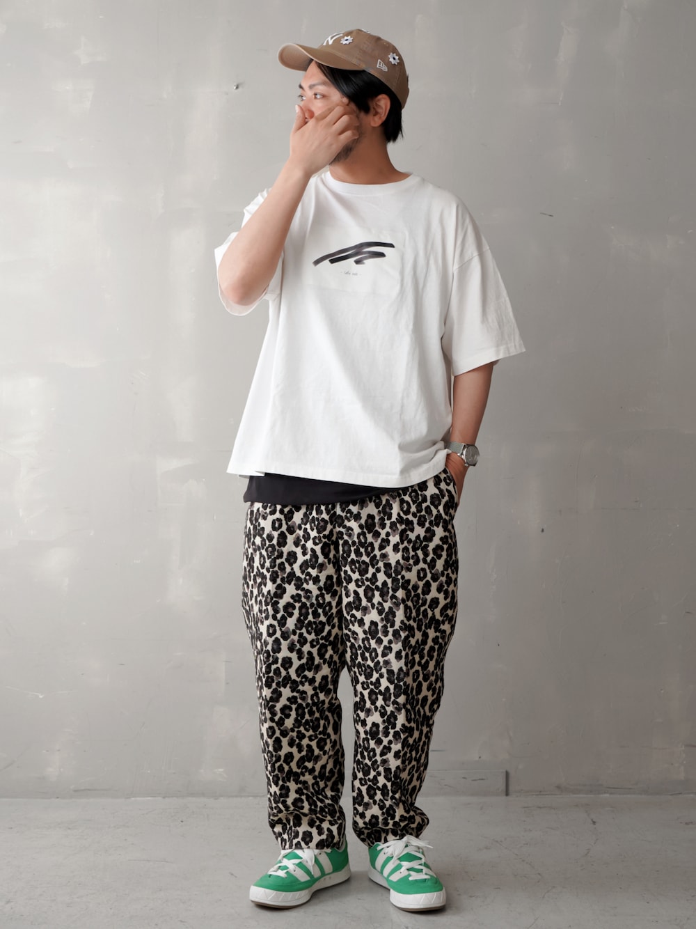 グリーン系のスニーカー、ホワイト系のTシャツ/カットソー、ベージュ系のキャップを着用したメンズの春コーディネートの1枚目の写真