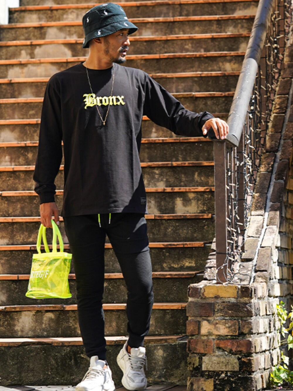 ブラック系のスウェットパンツ、イエロー系のトートバッグ、ブラック系のTシャツ/カットソーを着用したメンズの秋コーディネートの1枚目の写真