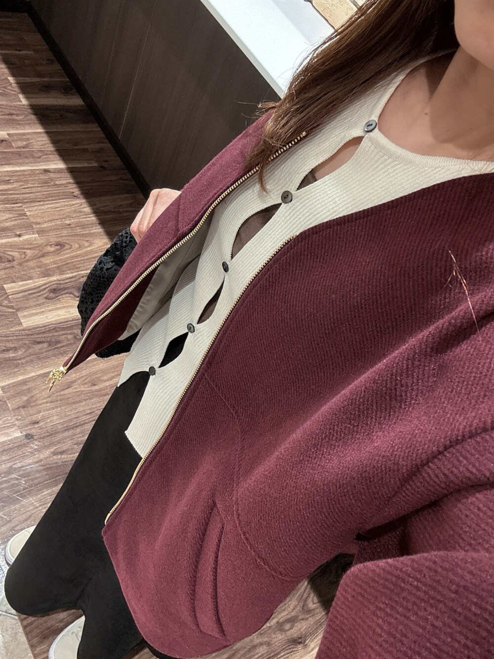 レッド系のブルゾン、ホワイト系のニット/セーター、ブラウン系のキャミソールを着用したレディースの秋コーディネートの1枚目の写真