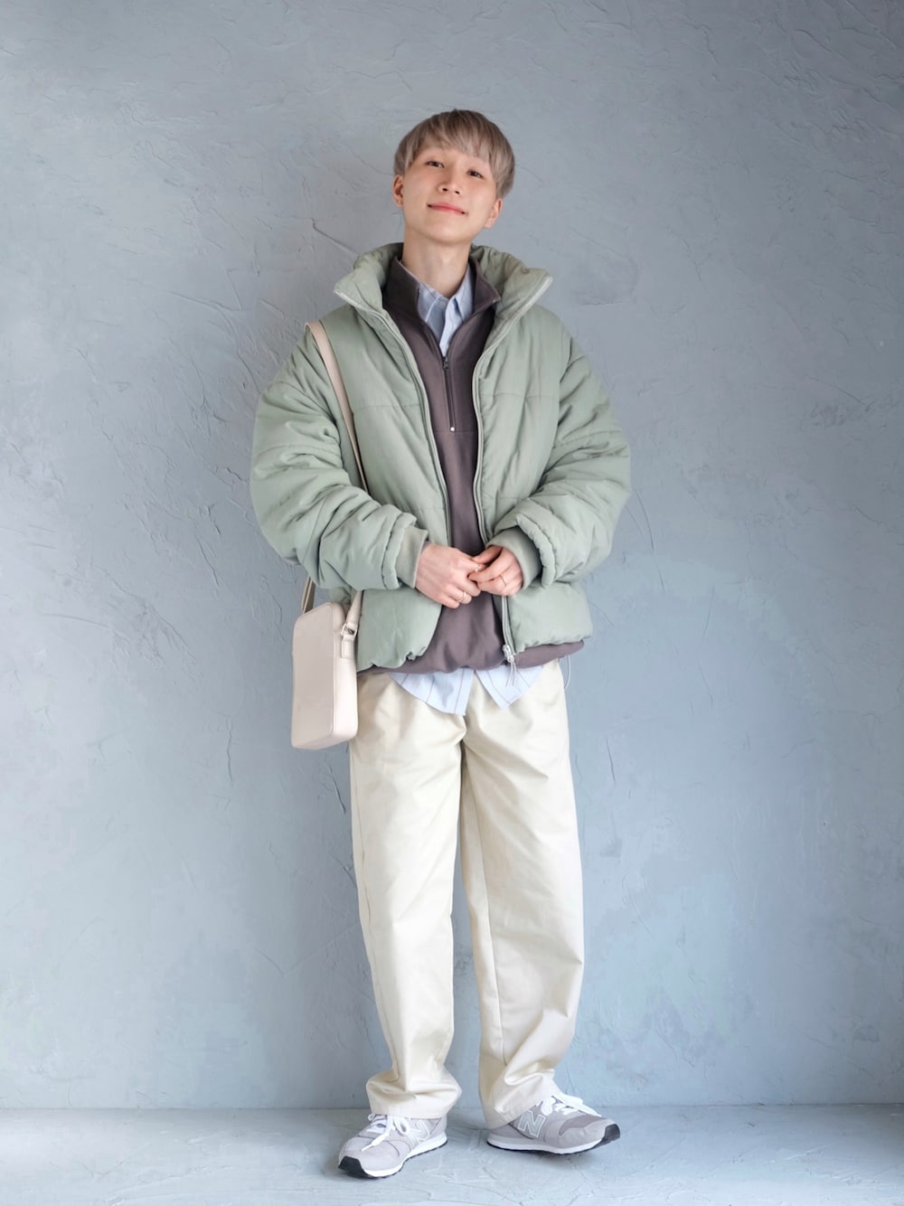 グレー系のスニーカー、ベージュ系のチノパンツ、グレー系のスウェットを着用したメンズの冬コーディネートの1枚目の写真