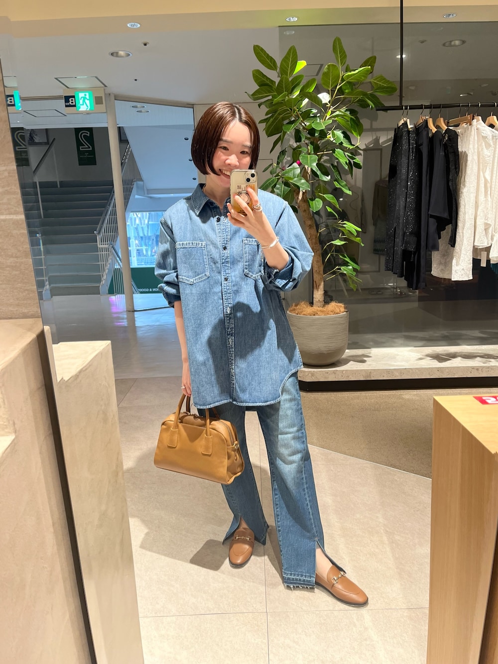 ブルー系のシャツ/ブラウス、ブルー系のデニムパンツ、イエロー系のボストンバッグを着用したレディースの冬コーディネートの1枚目の写真