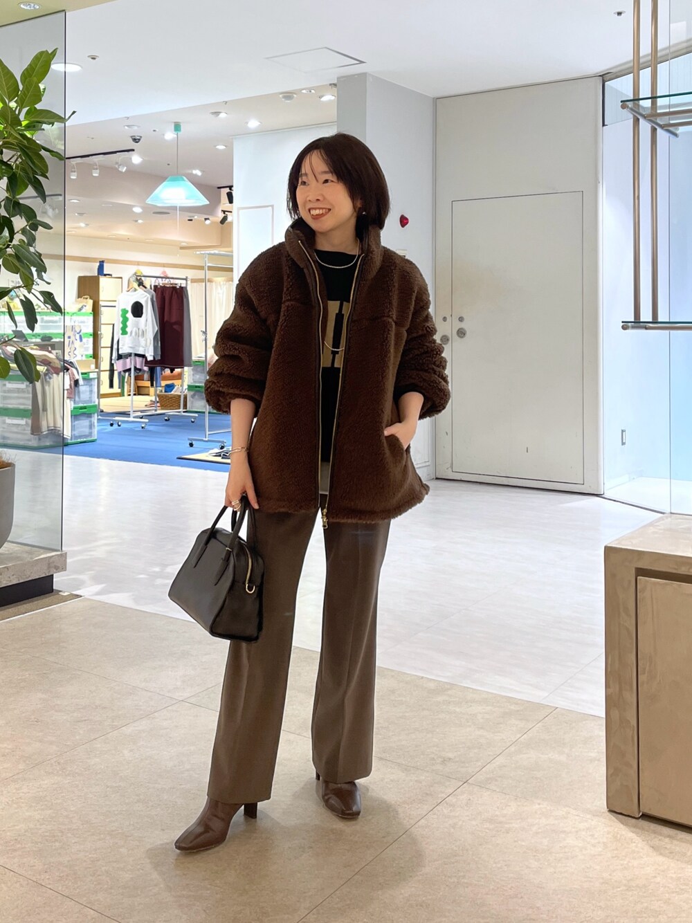 ブラウン系のその他パンツ、ブラウン系のボストンバッグ、ブラウン系のブーツを着用したレディースの秋コーディネートの1枚目の写真