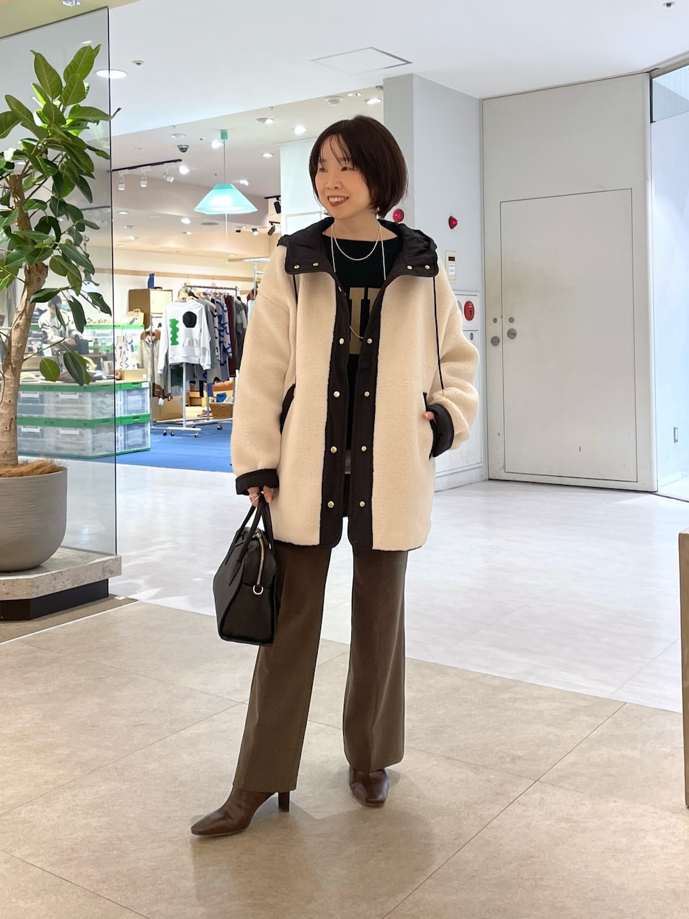 ブラック系のスウェット、ブラウン系のその他パンツ、ブラック系のボストンバッグを着用したレディースの秋コーディネートの1枚目の写真