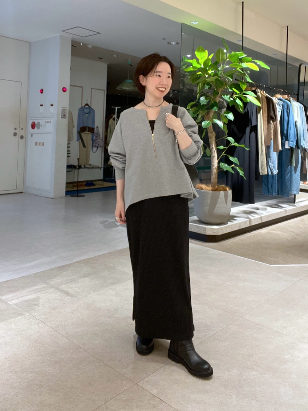 ブラック系のワンピース、グレー系のスウェット、ブラック系のショルダーバッグを着用したレディースの秋コーディネートの1枚目の写真