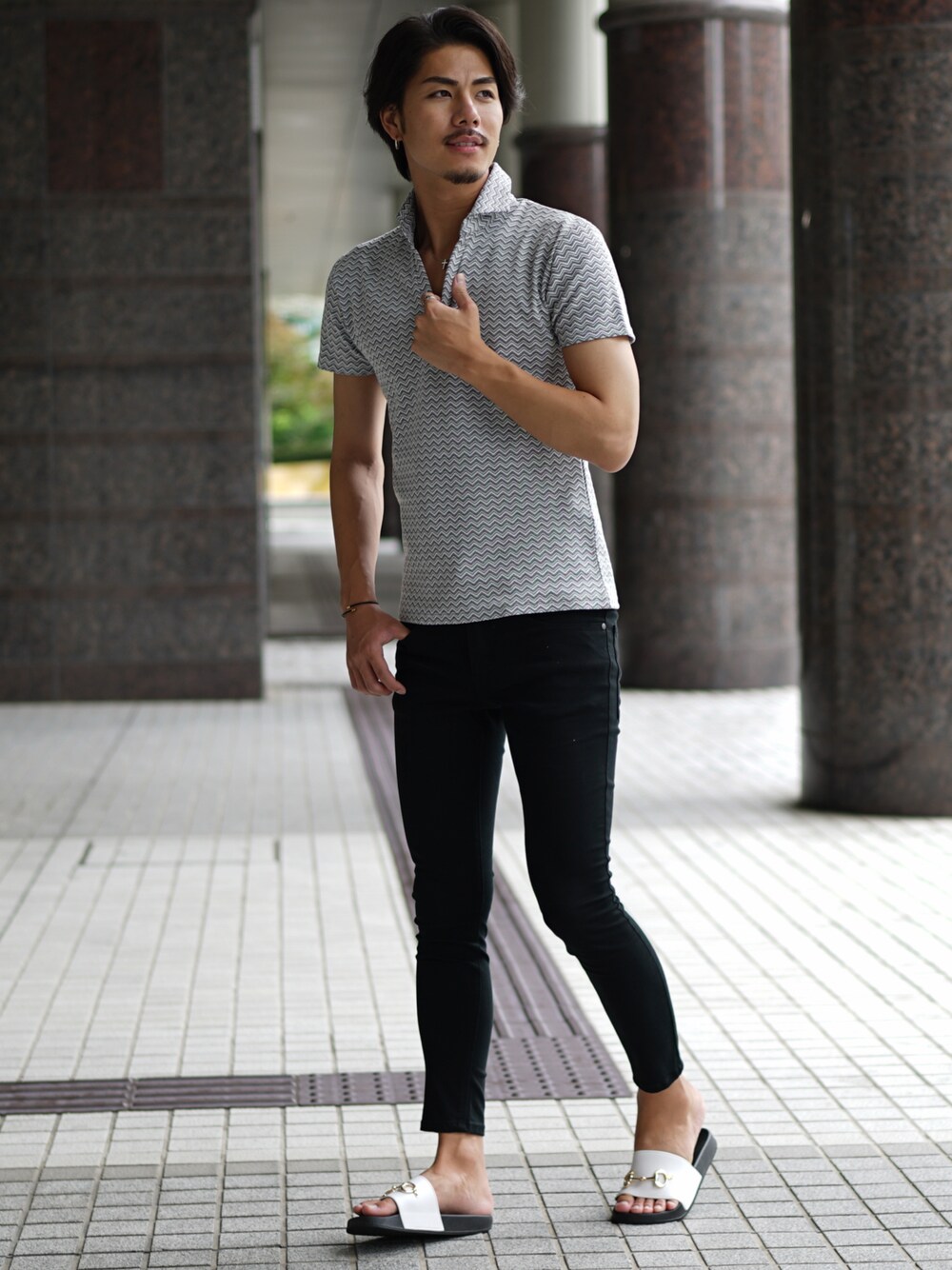 ホワイト系のポロシャツ、ブラック系のデニムパンツを着用したメンズの夏コーディネートの1枚目の写真