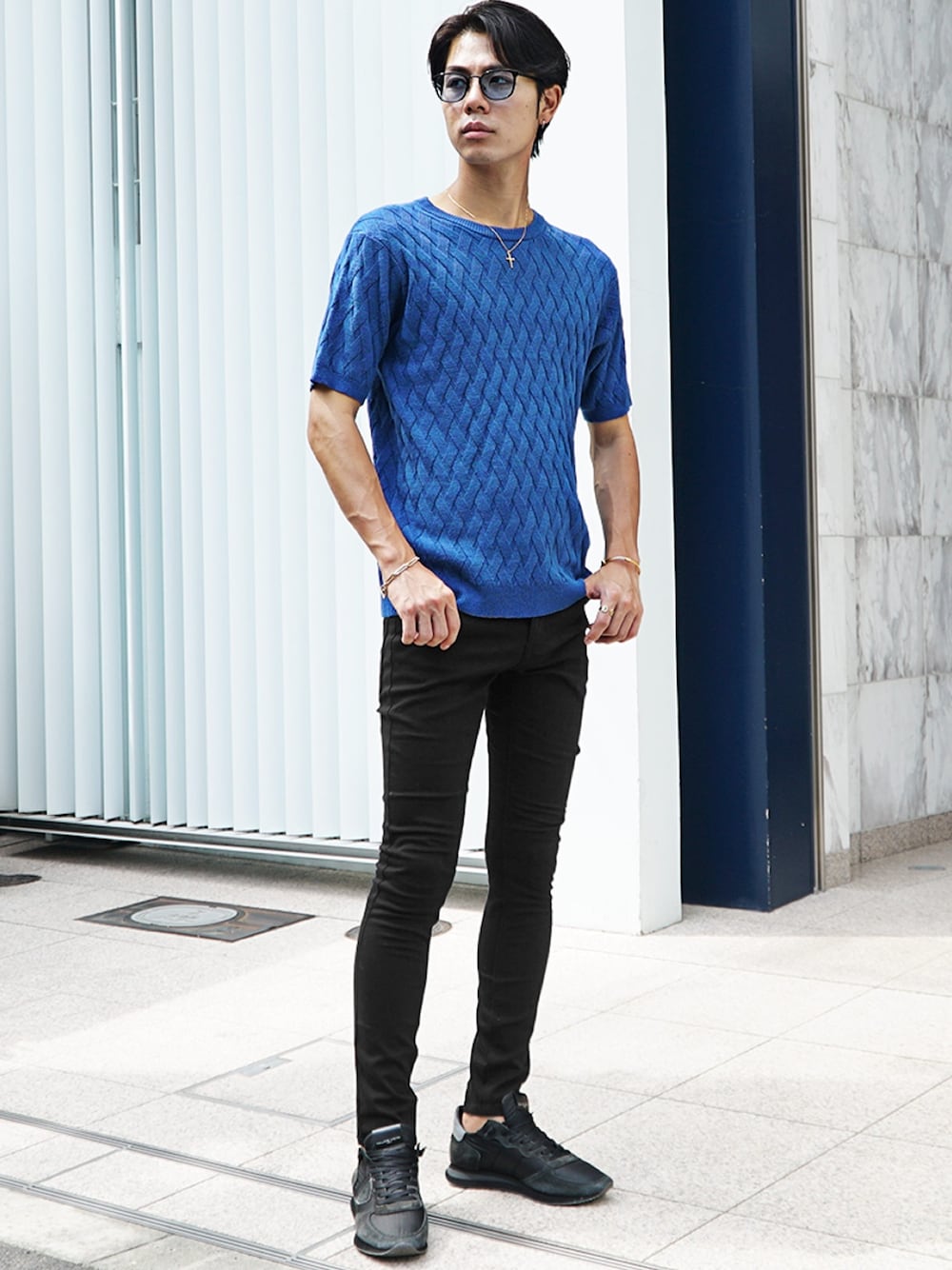 ブルー系のニット/セーター、ブラック系のデニムパンツを着用したメンズの夏コーディネートの1枚目の写真