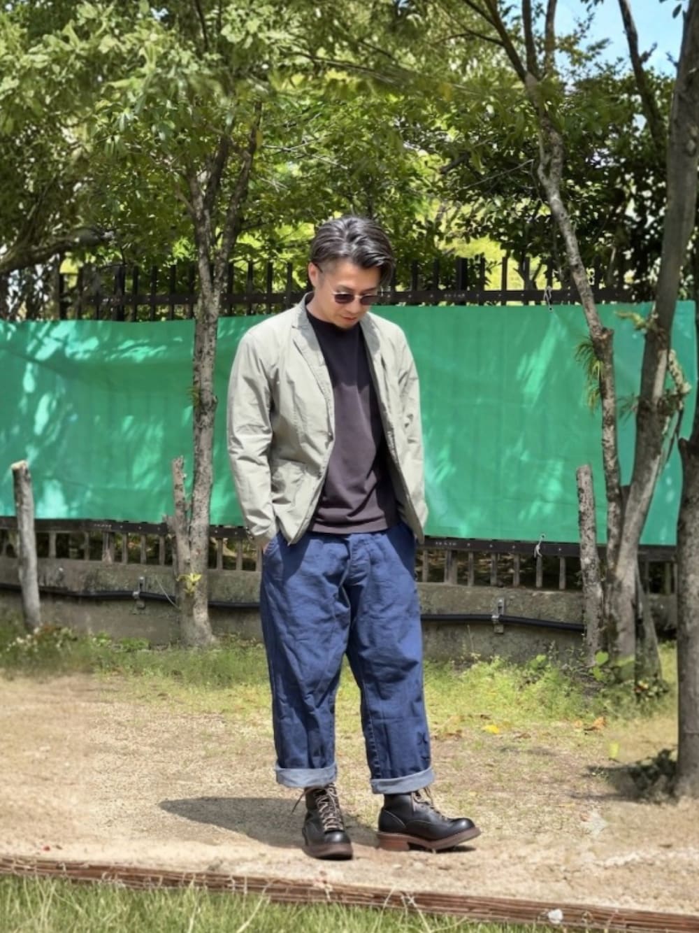 ブルー系のデニムパンツ、グレー系のTシャツ/カットソー、ブラック系のブーツを着用したメンズの春コーディネートの1枚目の写真