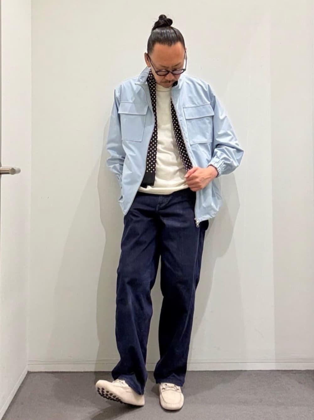 ホワイト系のニット/セーター、グレー系のスリッポン、ブルー系のデニムパンツを着用したメンズの夏コーディネートの1枚目の写真