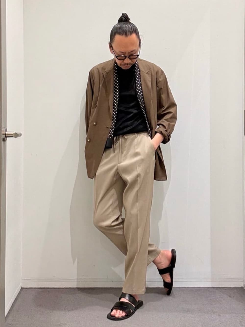 ブラウン系のテーラードジャケット、ブラック系のTシャツ/カットソー、ベージュ系のスラックスを着用したメンズの夏コーディネートの1枚目の写真