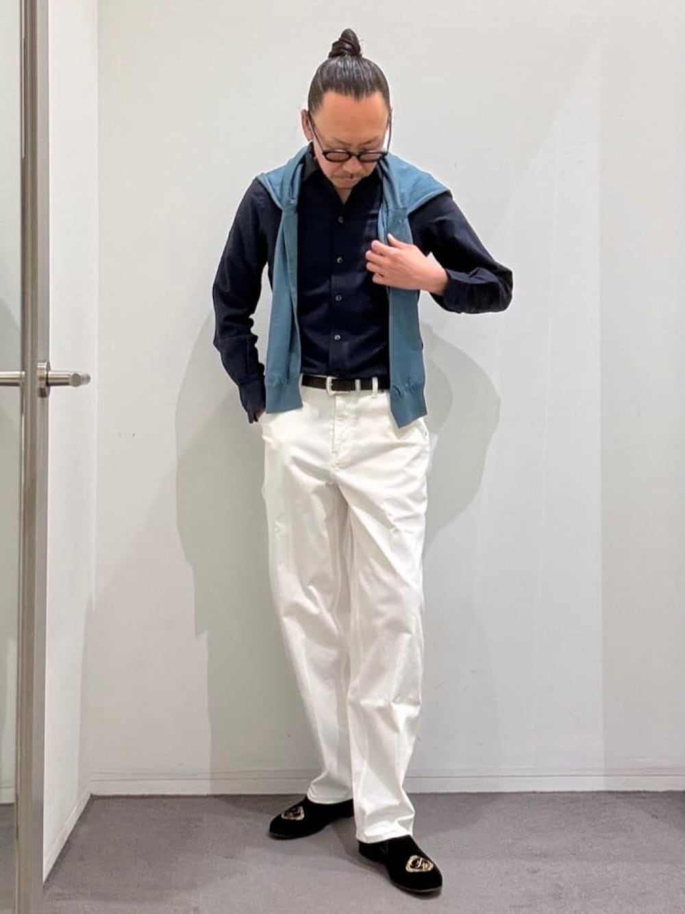 ブラック系のドレスシューズ、ホワイト系のデニムパンツ、ブルー系のニット/セーターを着用したメンズの春コーディネートの1枚目の写真