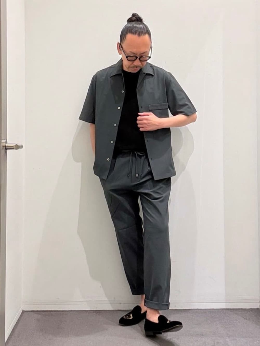 ブラック系のドレスシューズ、グレー系のスラックス、グレー系のシャツ/ブラウスを着用したメンズの夏コーディネートの1枚目の写真