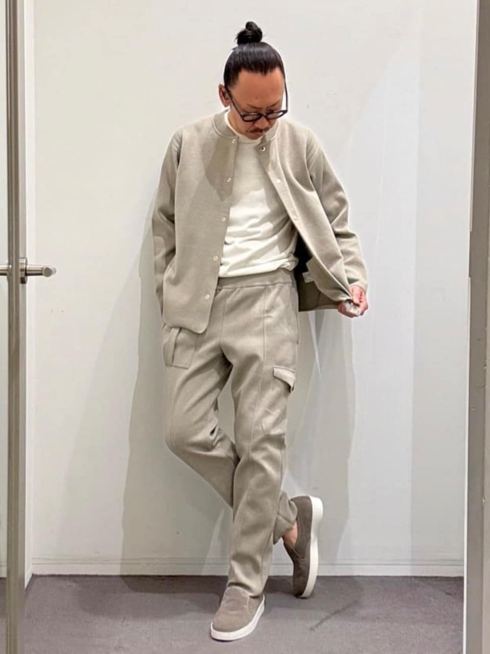 ベージュ系のブルゾン、ホワイト系のニット/セーター、ベージュ系のスラックスを着用したメンズの夏コーディネートの1枚目の写真