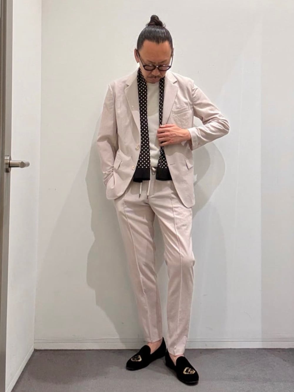 ベージュ系のテーラードジャケット、ベージュ系のスラックス、ブラック系のドレスシューズを着用したメンズの夏コーディネートの1枚目の写真