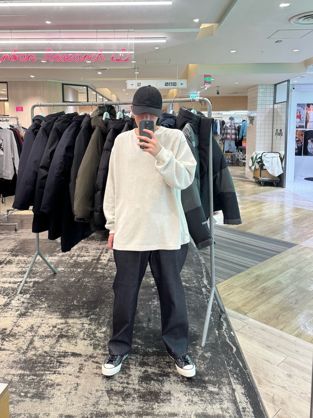 ホワイト系のニット/セーター、ブルー系のデニムパンツ、ブラック系のスニーカーを着用したメンズの冬コーディネートの1枚目の写真