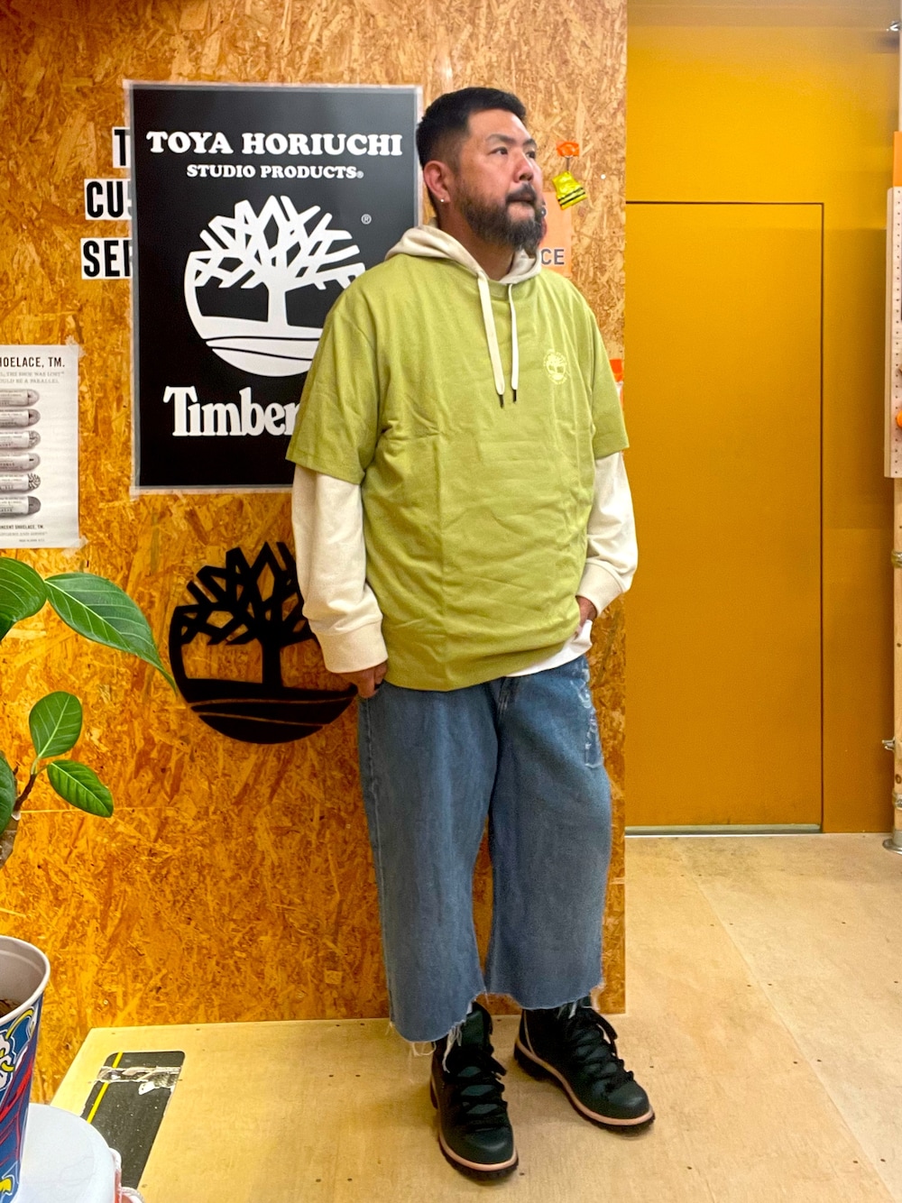 グリーン系のTシャツ/カットソー、ホワイト系のパーカー、ブルー系のデニムパンツを着用したメンズの秋コーディネートの1枚目の写真