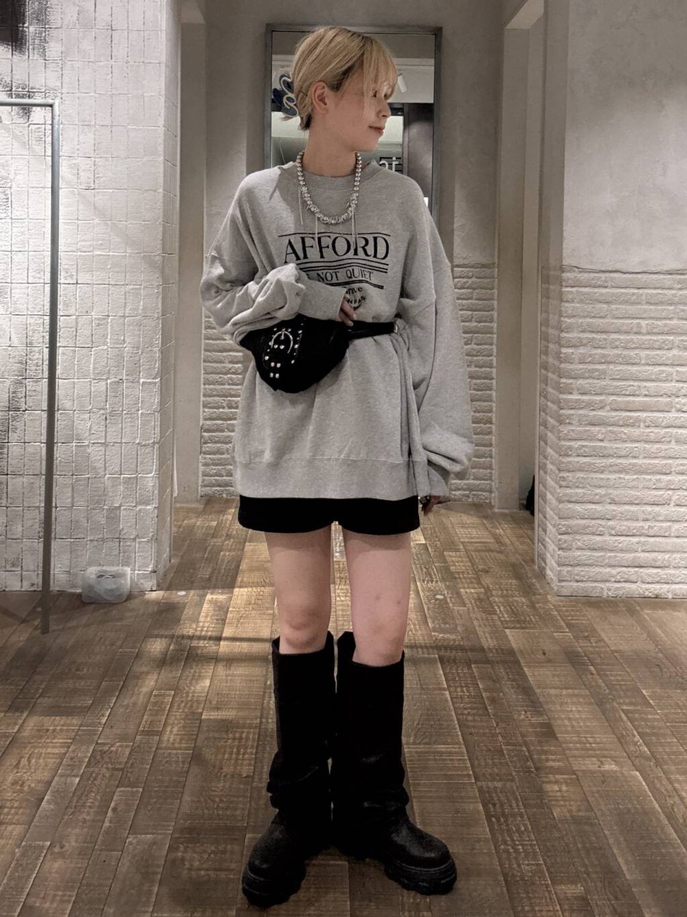 ブラック系のショルダーバッグ、ブラック系のブーツ、グレー系のスウェットを着用したレディースの秋コーディネートの1枚目の写真