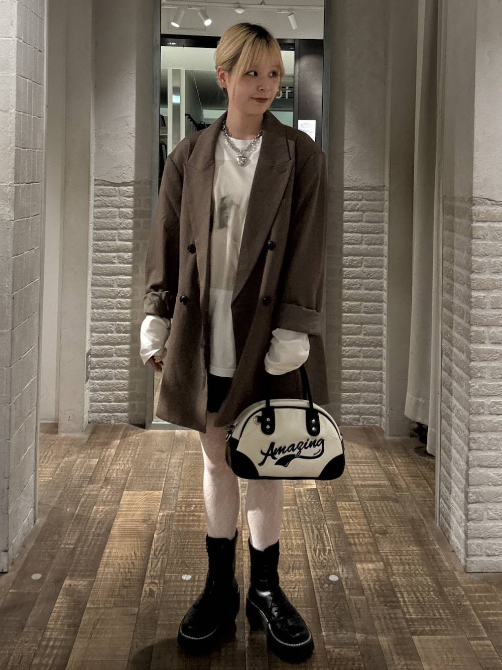 グレー系のテーラードジャケット、ホワイト系のショルダーバッグ、ホワイト系のTシャツ/カットソーを着用したレディースの秋コーディネートの1枚目の写真