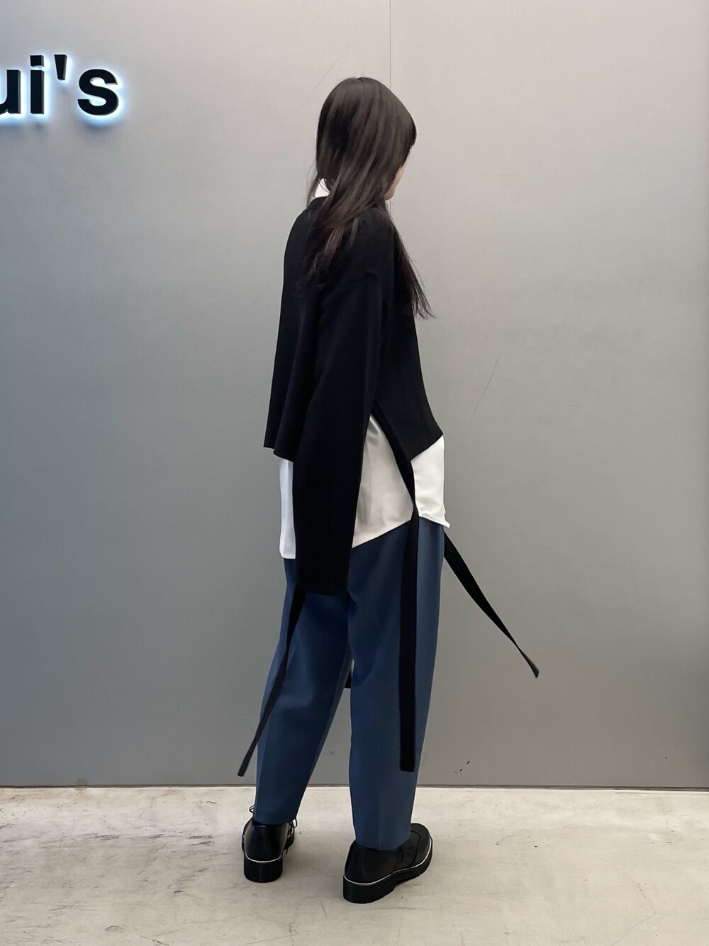 ブルー系のスラックス、ブラック系のニット/セーターを着用したレディースの春コーディネートの3枚目の写真