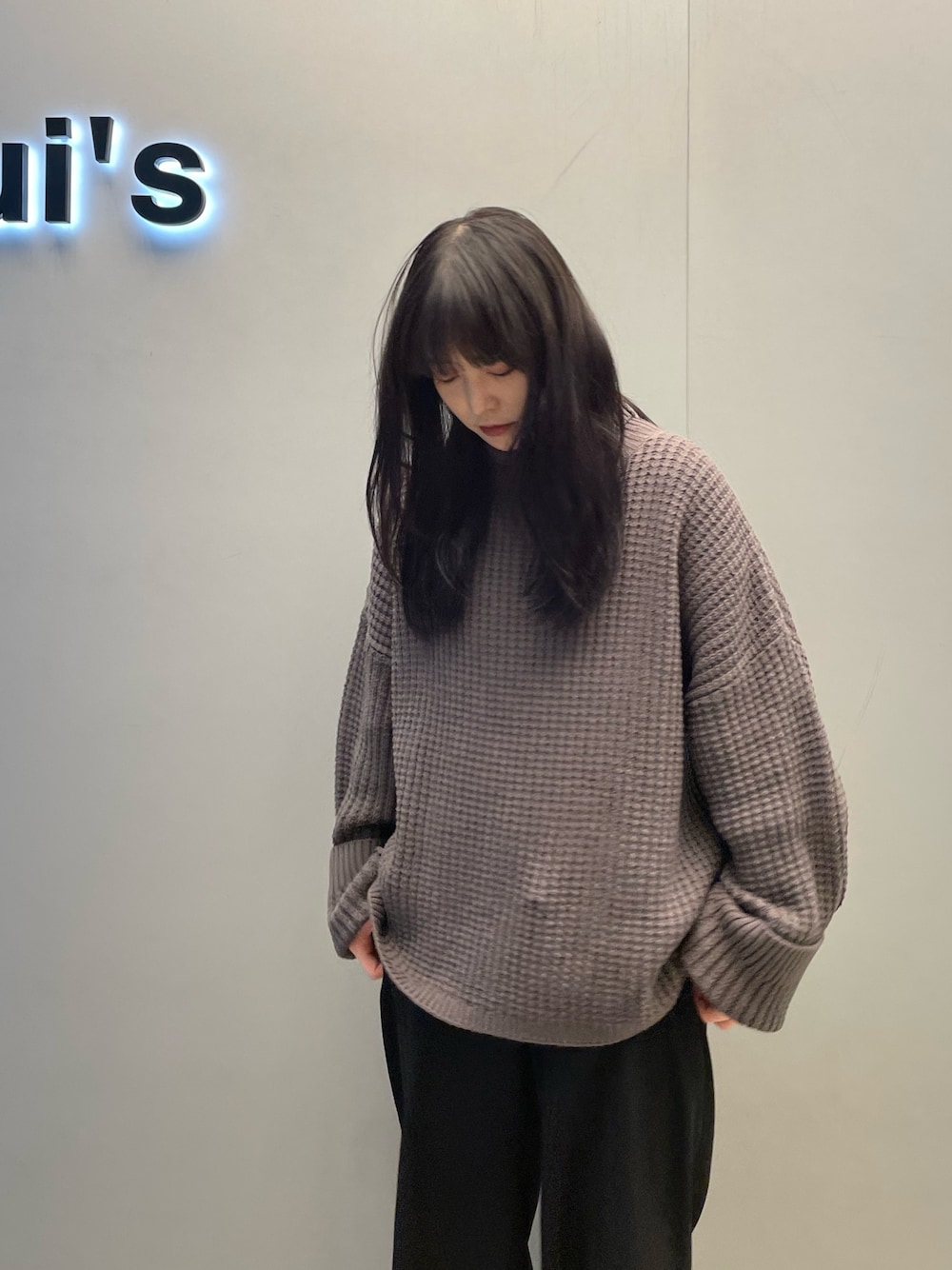 グレー系のニット/セーター、ホワイト系のスニーカーを着用したレディースの冬コーディネートの3枚目の写真