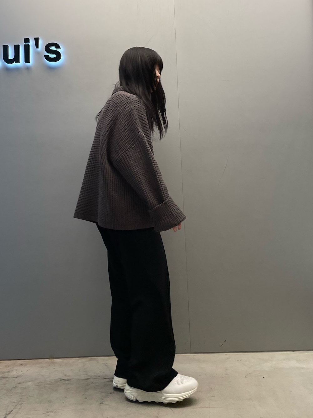 グレー系のニット/セーター、ホワイト系のスニーカーを着用したレディースの冬コーディネートの2枚目の写真