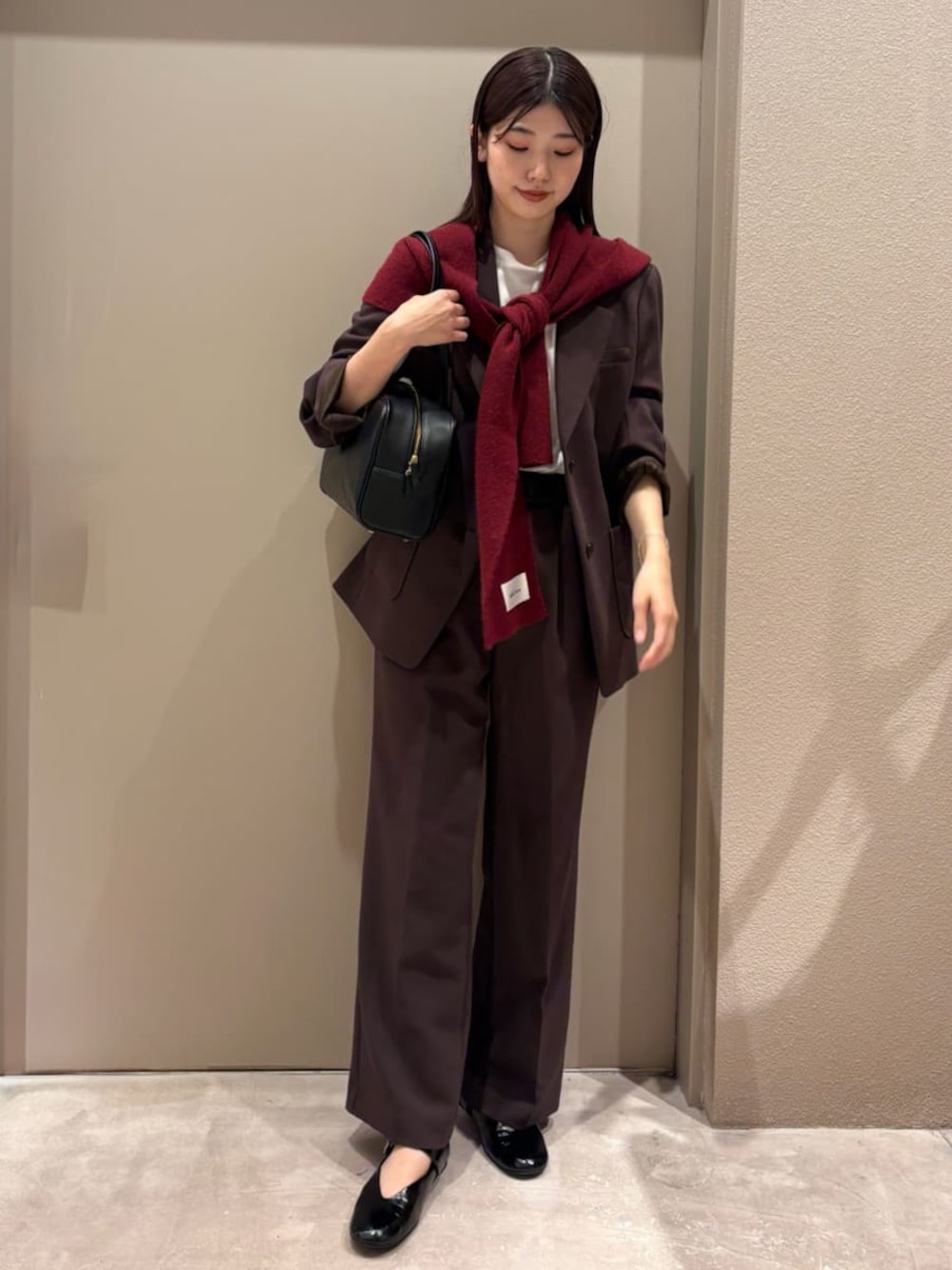 ブラウン系のテーラードジャケット、ブラウン系のその他パンツ、ホワイト系のTシャツ/カットソーを着用したレディースの秋コーディネートの1枚目の写真