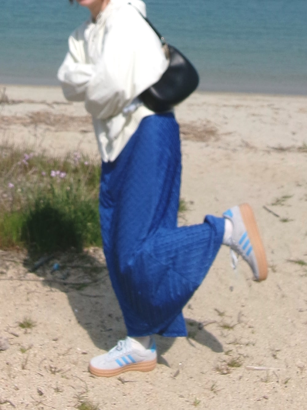 ブルー系のスニーカー、ホワイト系のジャケット/アウター、ブルー系のスカートを着用したレディースの秋コーディネートの1枚目の写真