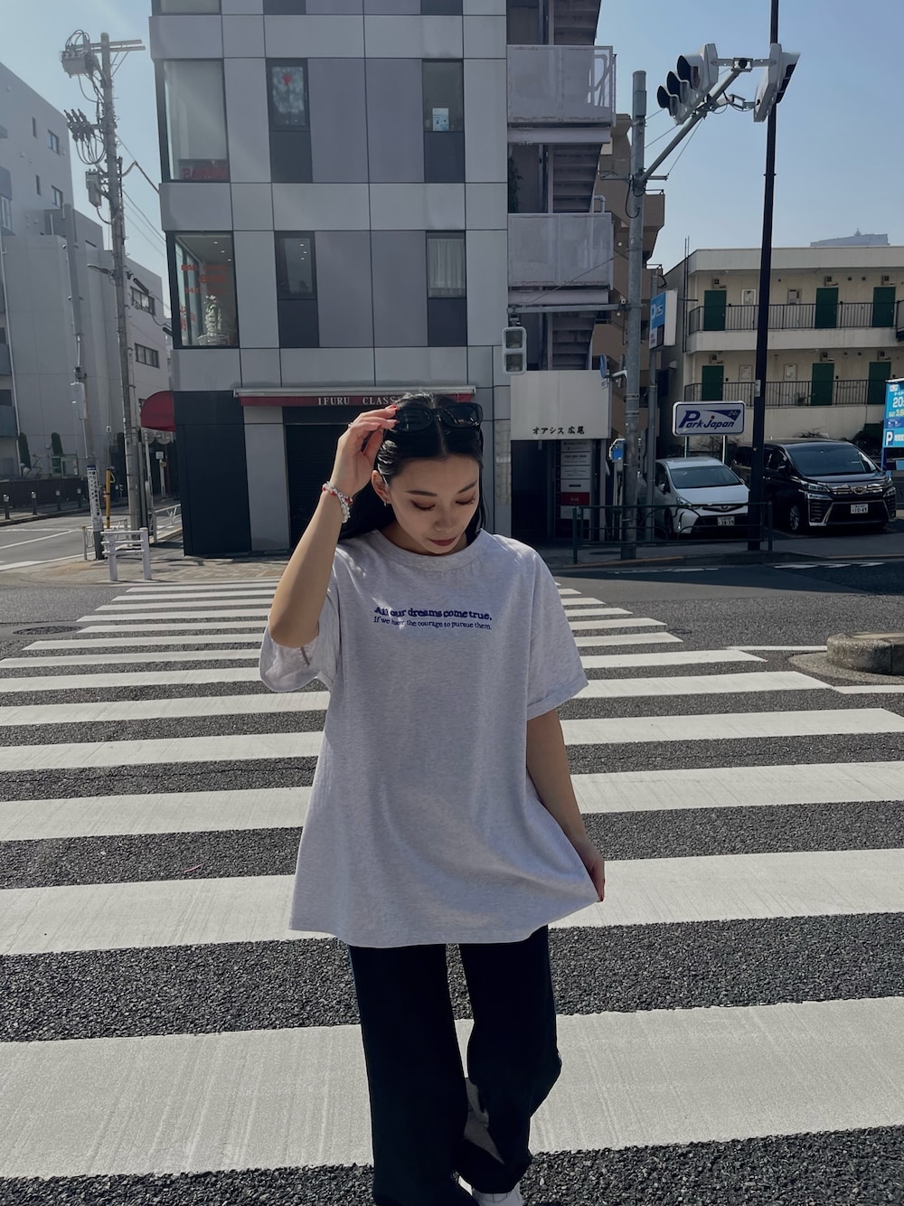 グレー系のTシャツ/カットソー、ブラック系のスラックス、ホワイト系のスニーカーを着用したレディースの春コーディネートの1枚目の写真