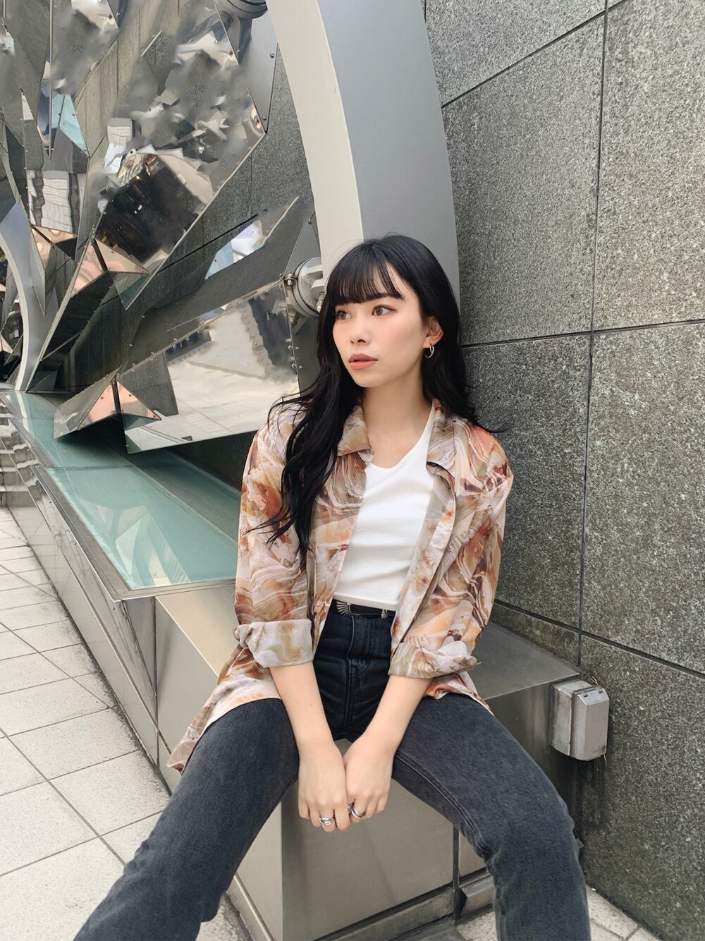ブラック系のデニムパンツ、ブラック系のパンプス、ホワイト系のTシャツ/カットソーを着用したレディースの春コーディネートの1枚目の写真