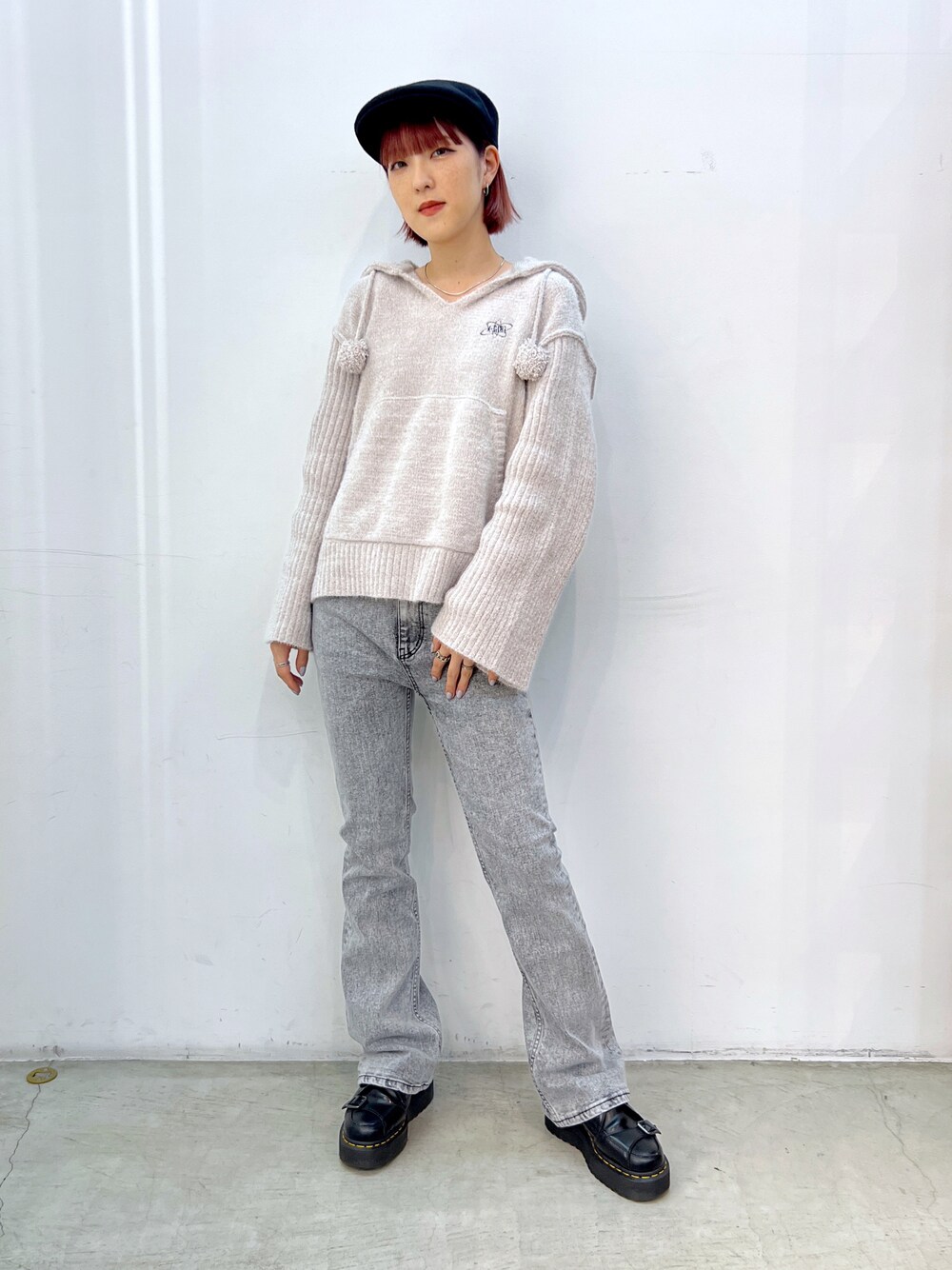 グレー系のデニムパンツ、ホワイト系のニット/セーター、ブラック系のハンチング/ベレー帽を着用したレディースの秋コーディネートの1枚目の写真
