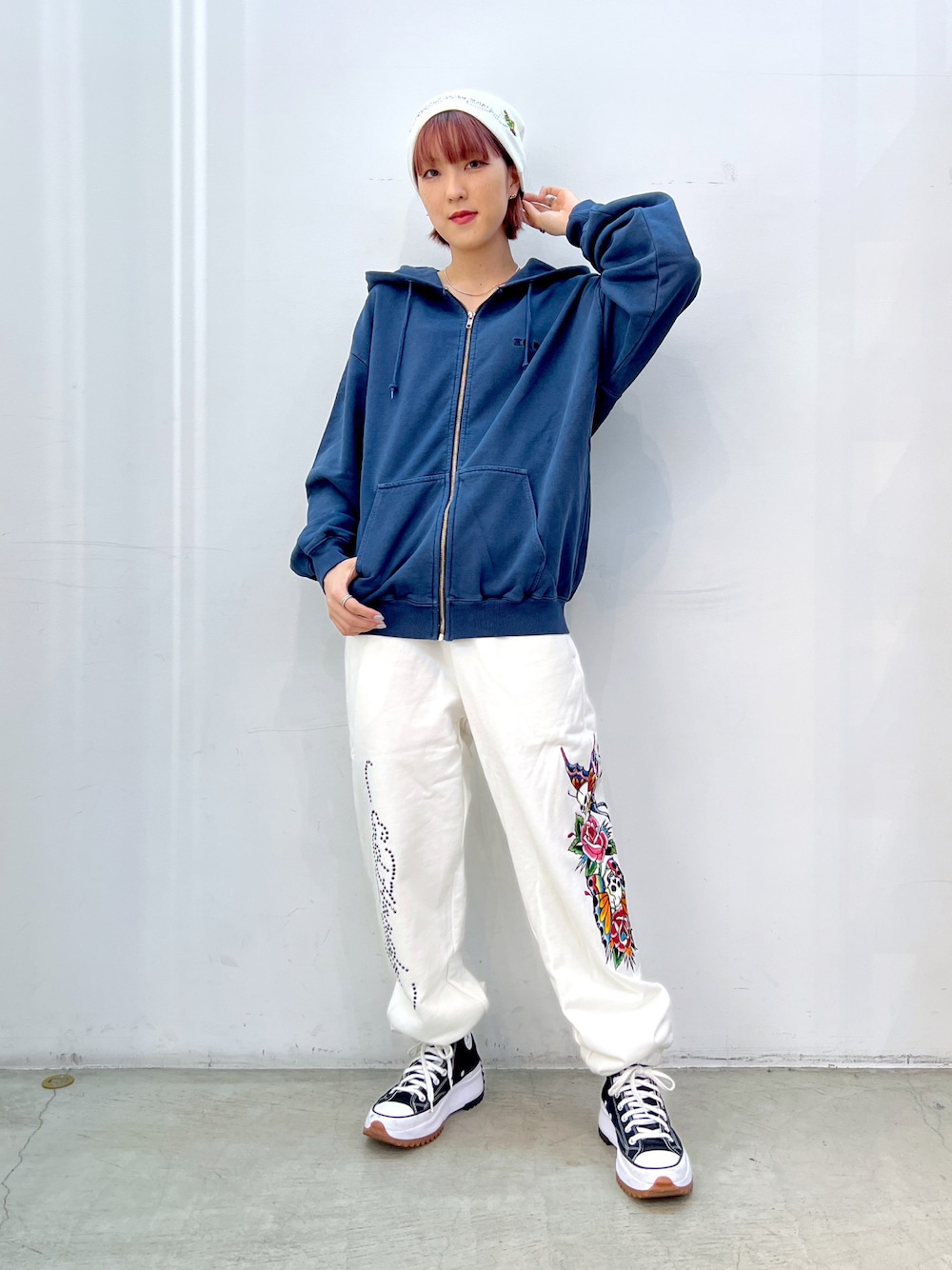 ホワイト系のその他パンツ、ブルー系のパーカー、ホワイト系のキャップを着用したレディースの秋コーディネートの1枚目の写真