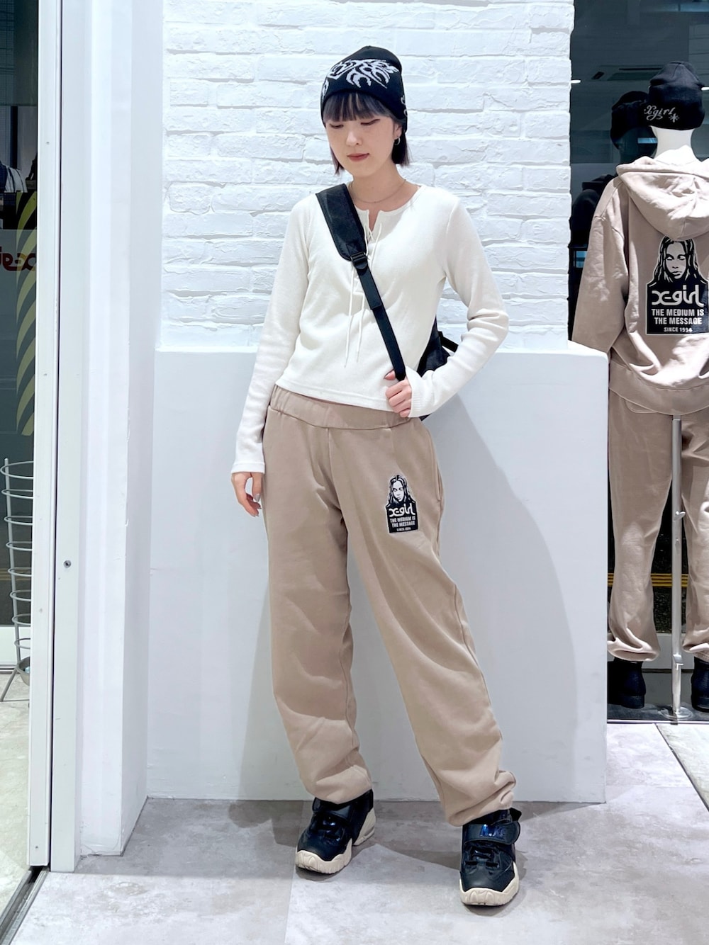 ベージュ系のスウェットパンツ、ホワイト系のTシャツ/カットソー、ブラック系のバックパック/リュックを着用したレディースの冬コーディネートの1枚目の写真