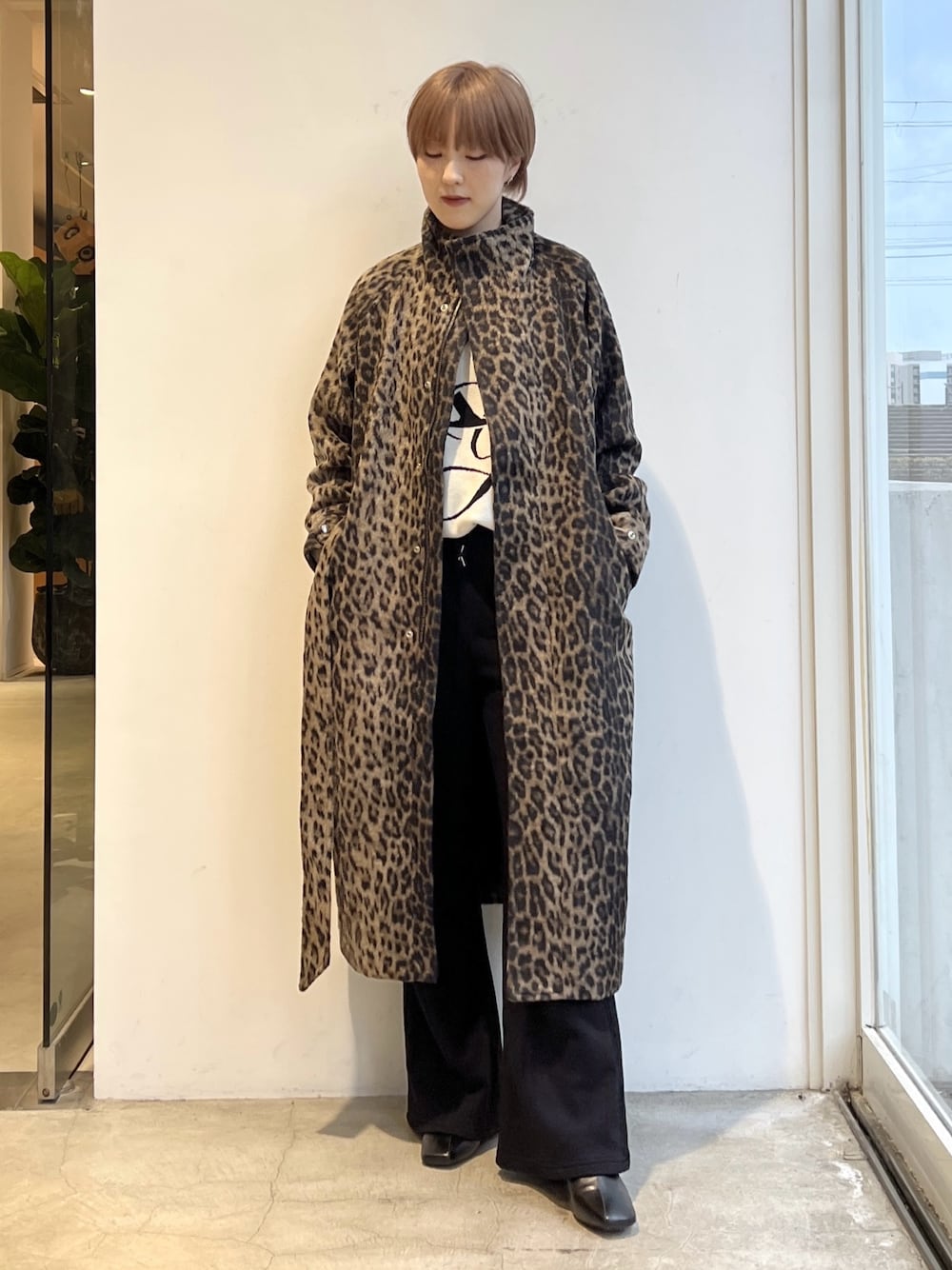 ブラック系のスウェットパンツ、ホワイト系のニット/セーター、ベージュ系のステンカラーコートを着用したレディースの秋コーディネートの1枚目の写真