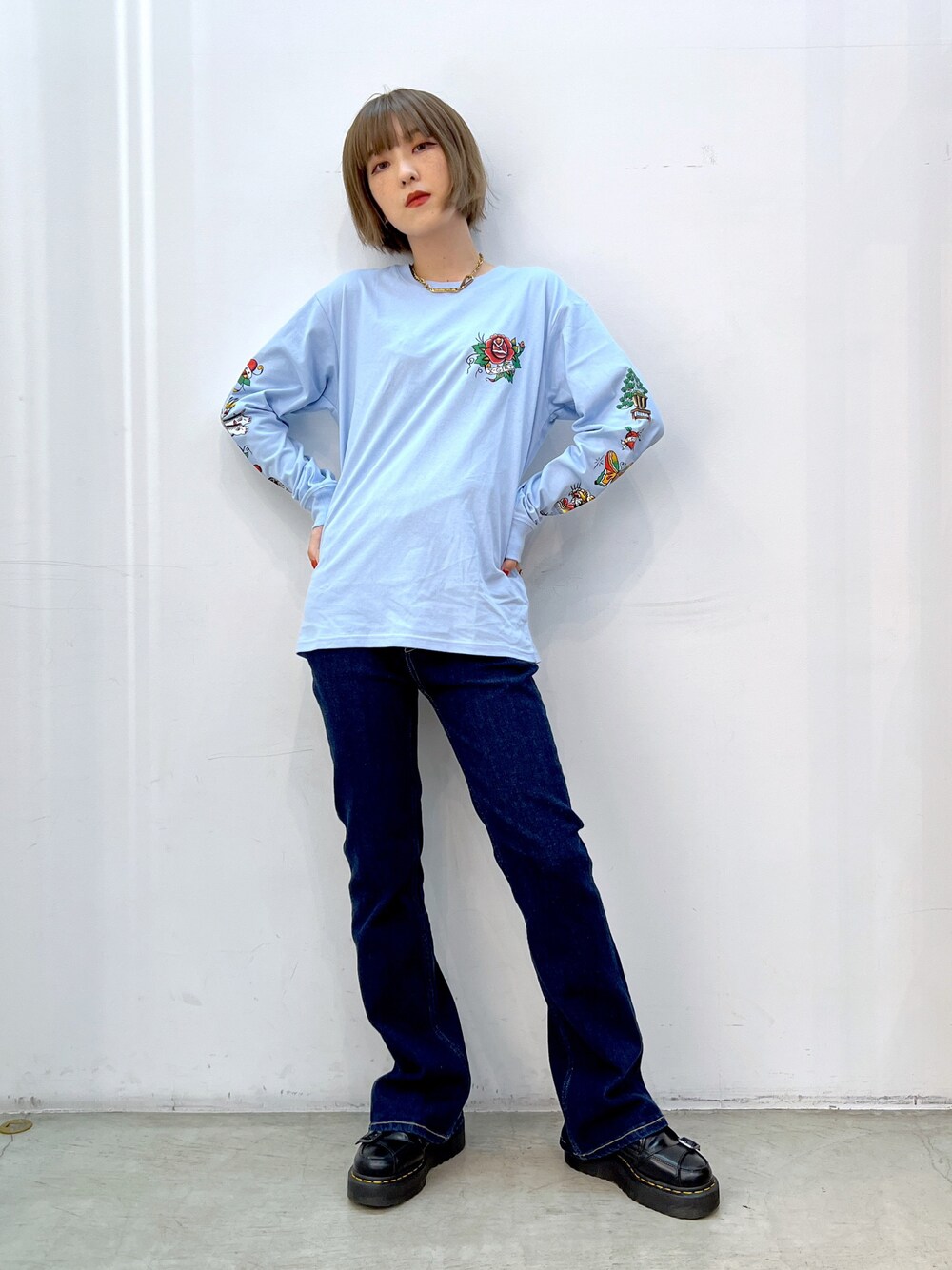 ブルー系のデニムパンツ、ブルー系のTシャツ/カットソー、ゴールド系のネックレスを着用したレディースの秋コーディネートの1枚目の写真