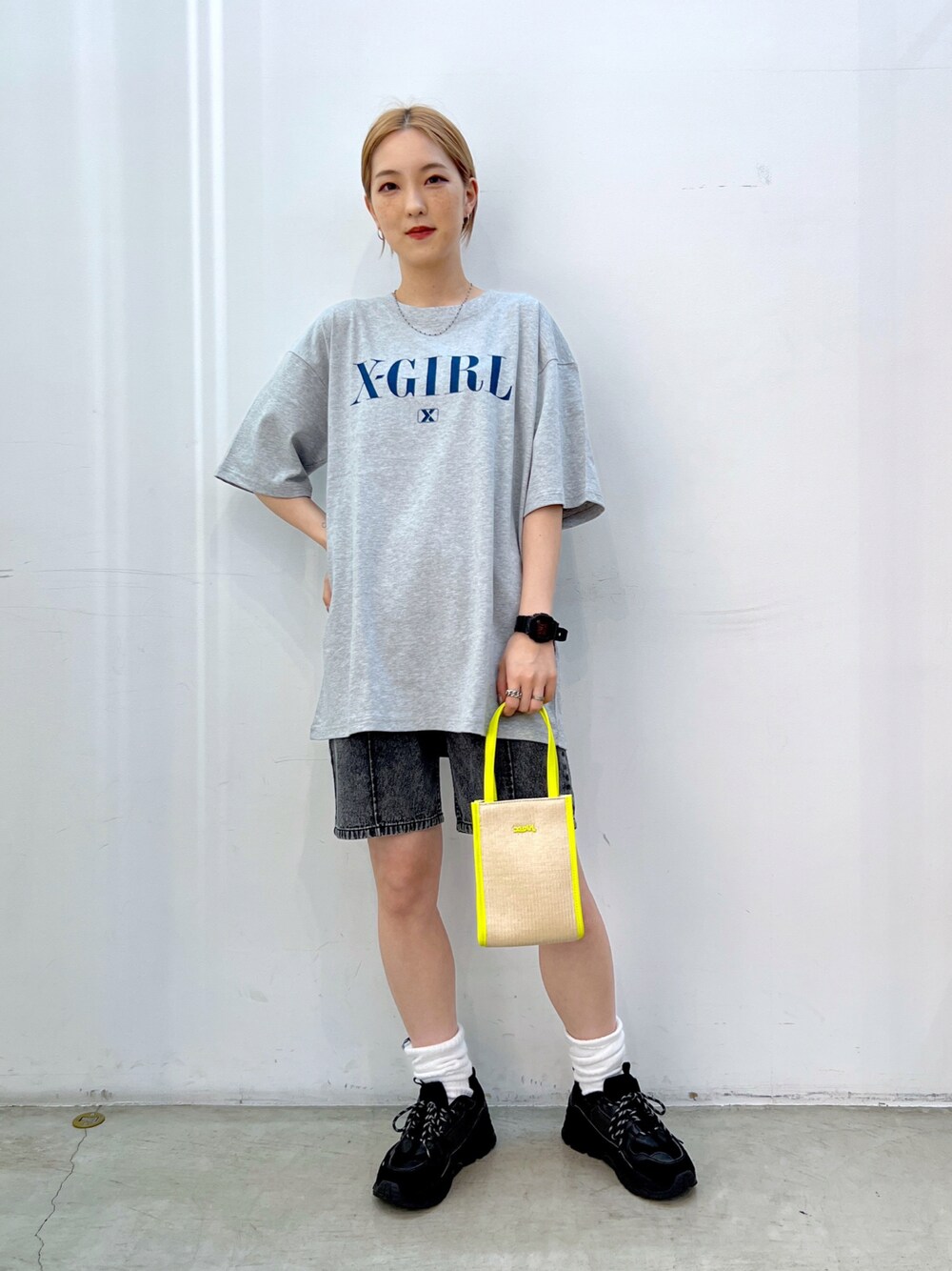 イエロー系のショルダーバッグ、ブラック系のデニムパンツ、グレー系のTシャツ/カットソーを着用したレディースの夏コーディネートの1枚目の写真