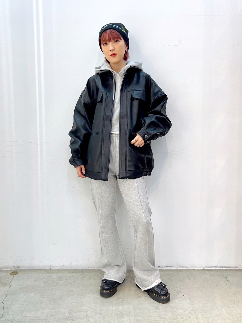 グレー系のスウェットパンツ、グレー系のパーカー、ブラック系のライダースジャケットを着用したレディースの秋コーディネートの1枚目の写真