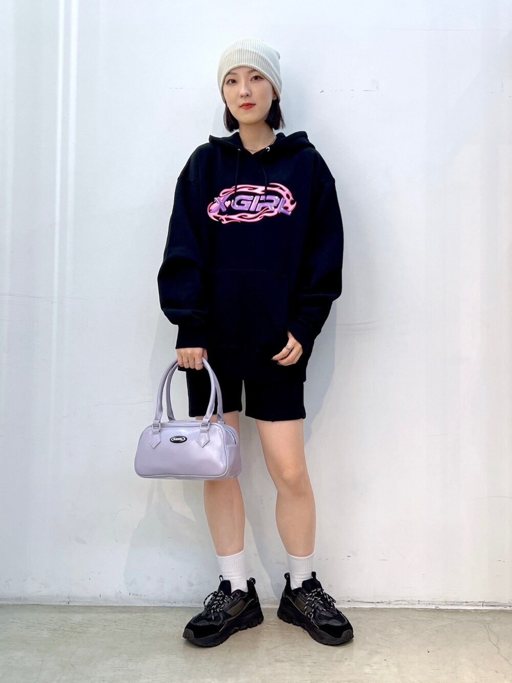 ブラック系のスウェットパンツ、パープル系のハンドバッグ、ブラック系のパーカーを着用したレディースの秋コーディネートの1枚目の写真