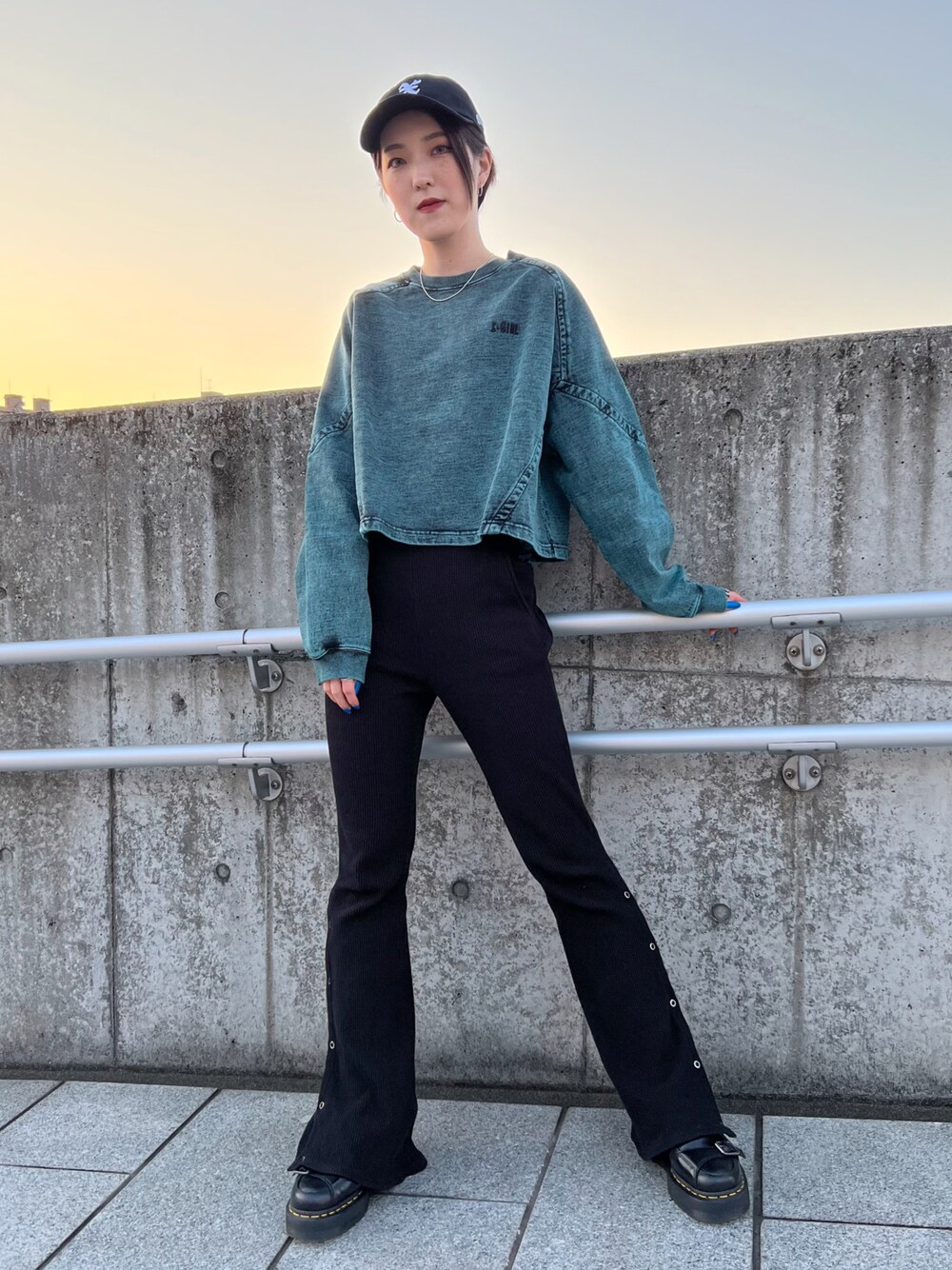 ブラック系のその他パンツ、グリーン系のスウェット、ブラック系のキャップを着用したレディースの春コーディネートの1枚目の写真