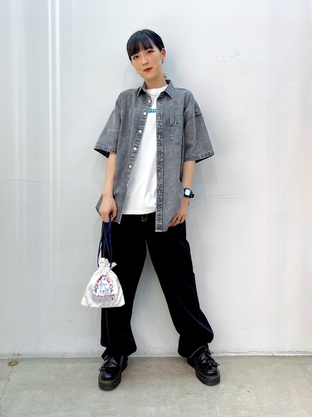 ブラック系のデニムパンツ、ホワイト系のショルダーバッグ、ホワイト系のTシャツ/カットソーを着用したレディースの夏コーディネートの1枚目の写真