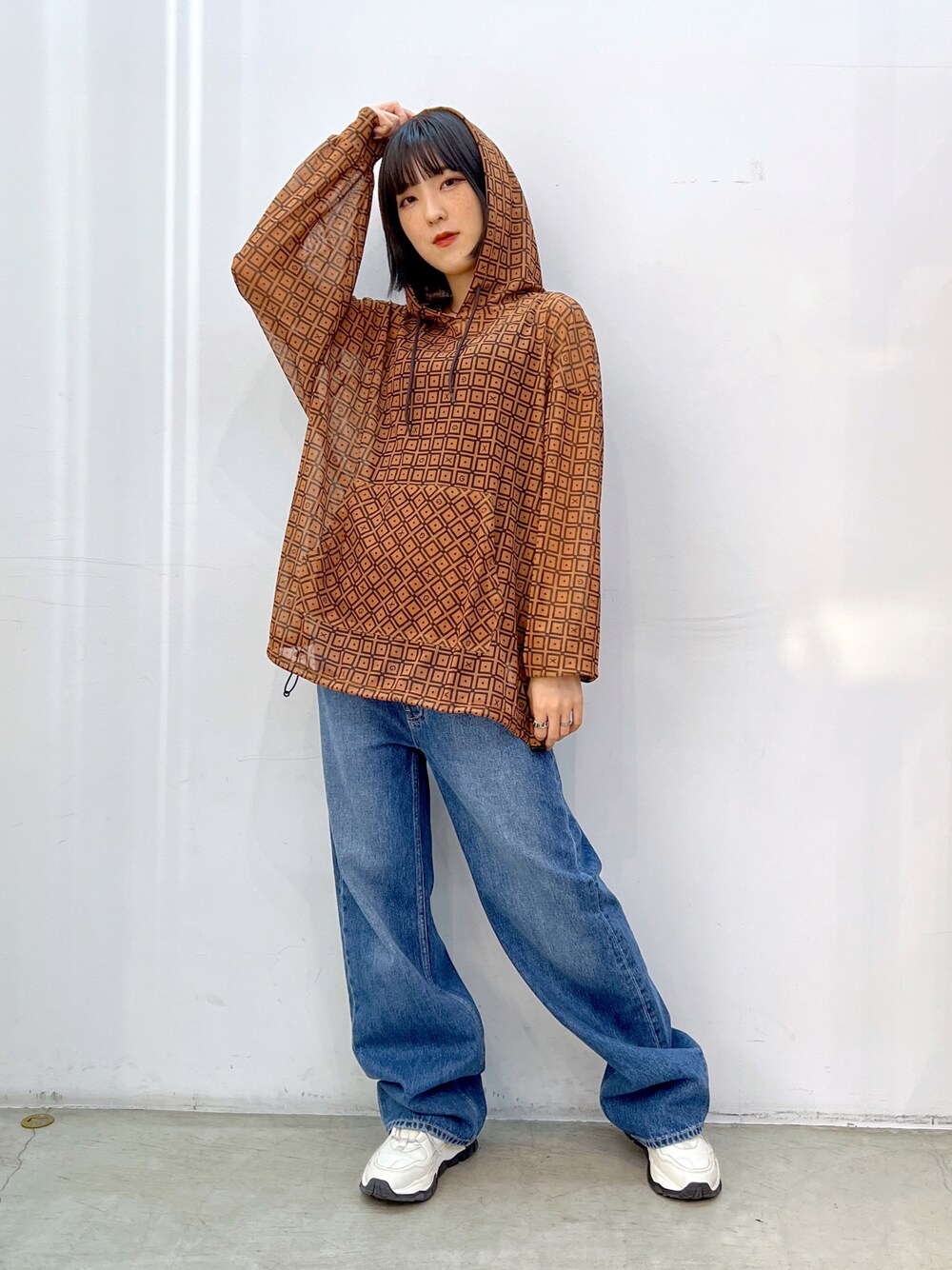 ブルー系のデニムパンツ、ブラウン系のパーカーを着用したレディースの夏コーディネートの1枚目の写真