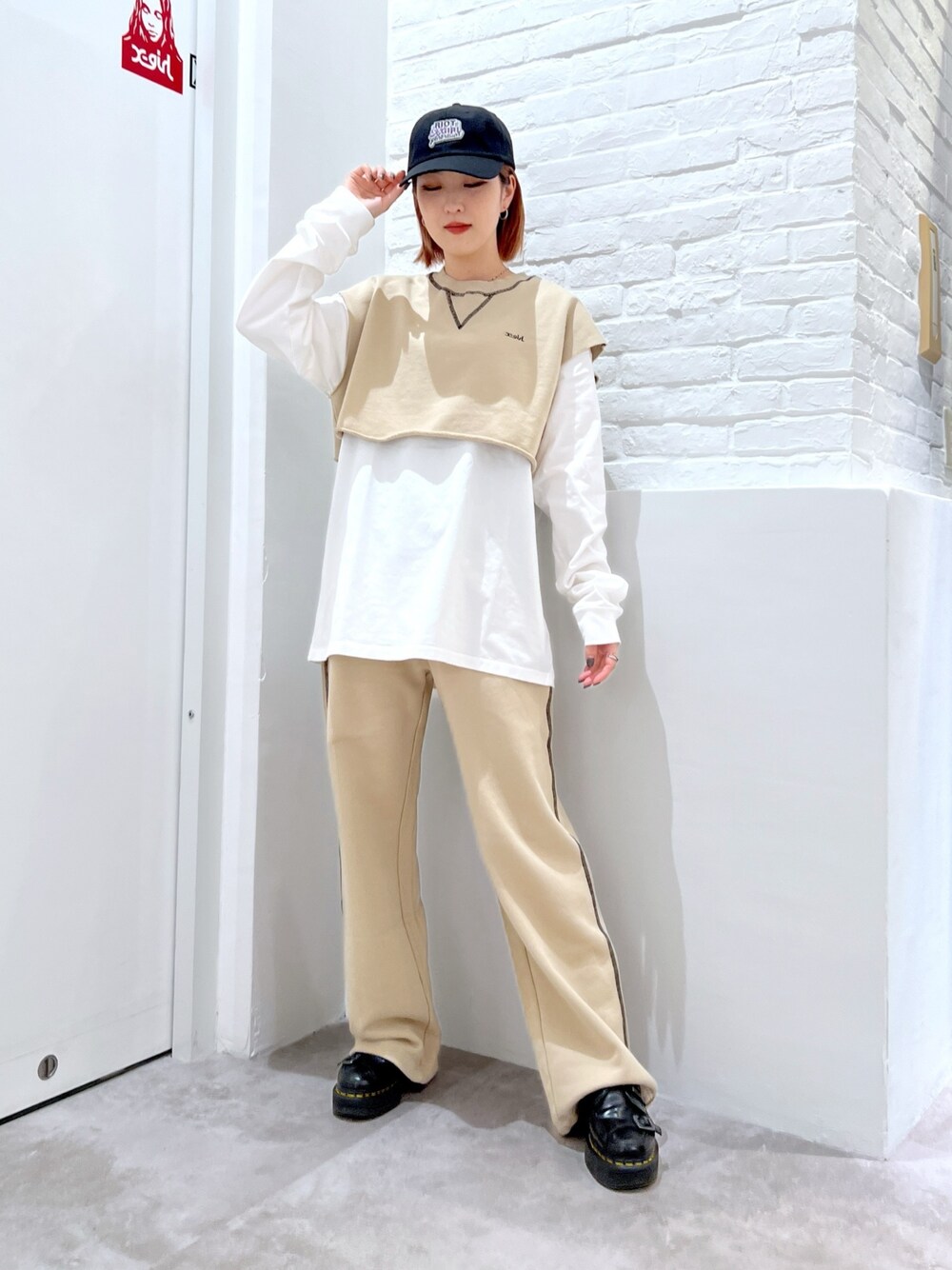 ベージュ系のスウェットパンツ、ホワイト系のTシャツ/カットソー、ベージュ系のベストを着用したレディースの春コーディネートの1枚目の写真