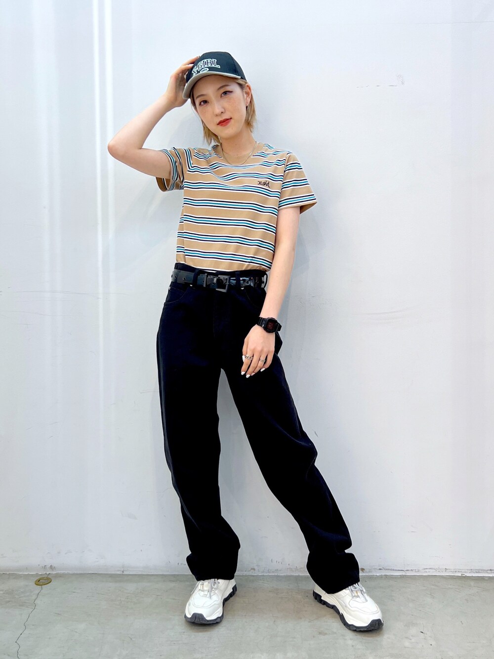 ブラック系のデニムパンツ、ベージュ系のTシャツ/カットソー、ブラック系のベルトを着用したレディースの夏コーディネートの1枚目の写真