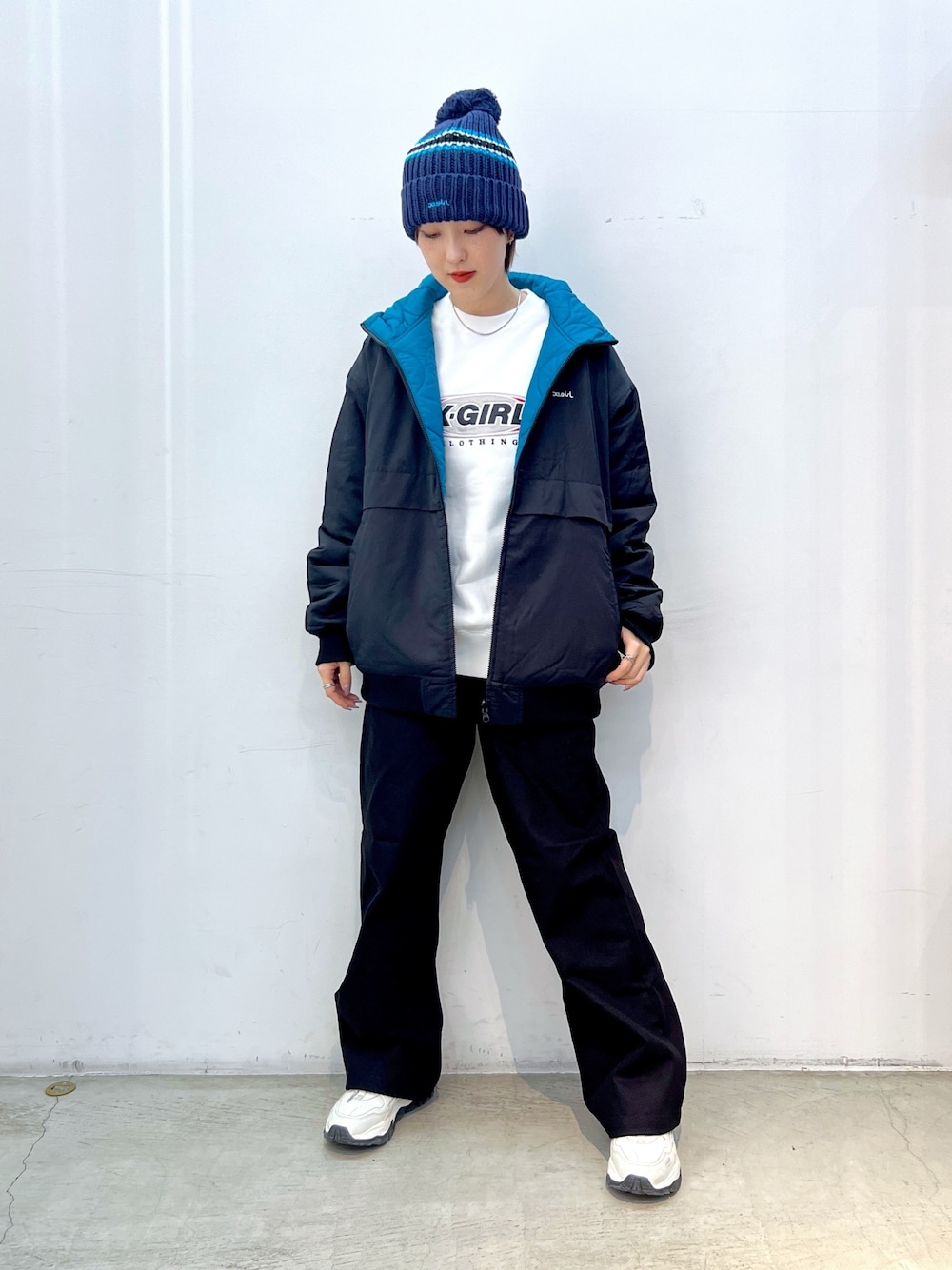 ブラック系のその他パンツ、ブラック系のナイロンジャケット、ホワイト系のスウェットを着用したレディースの冬コーディネートの1枚目の写真
