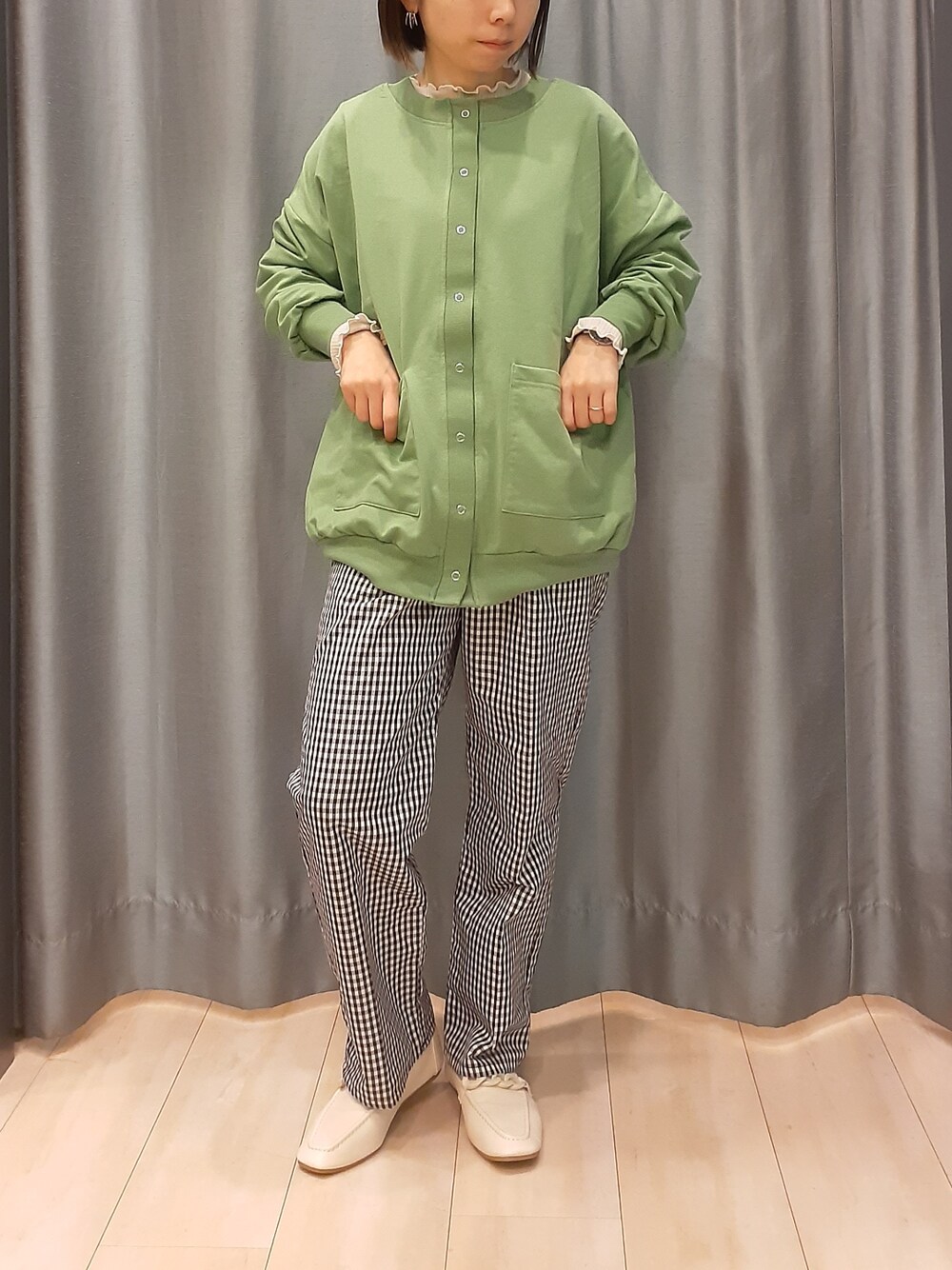 ベージュ系のTシャツ/カットソー、ブラック系のその他パンツ、グリーン系のカーディガン/ボレロを着用したレディースの春コーディネートの1枚目の写真