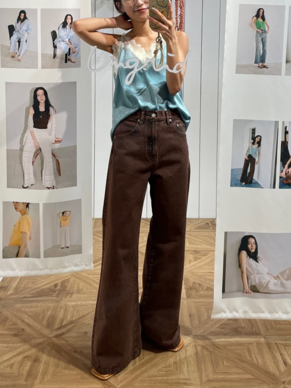 ブルー系のキャミソール、ブラウン系のデニムパンツを着用したレディースの冬コーディネートの1枚目の写真